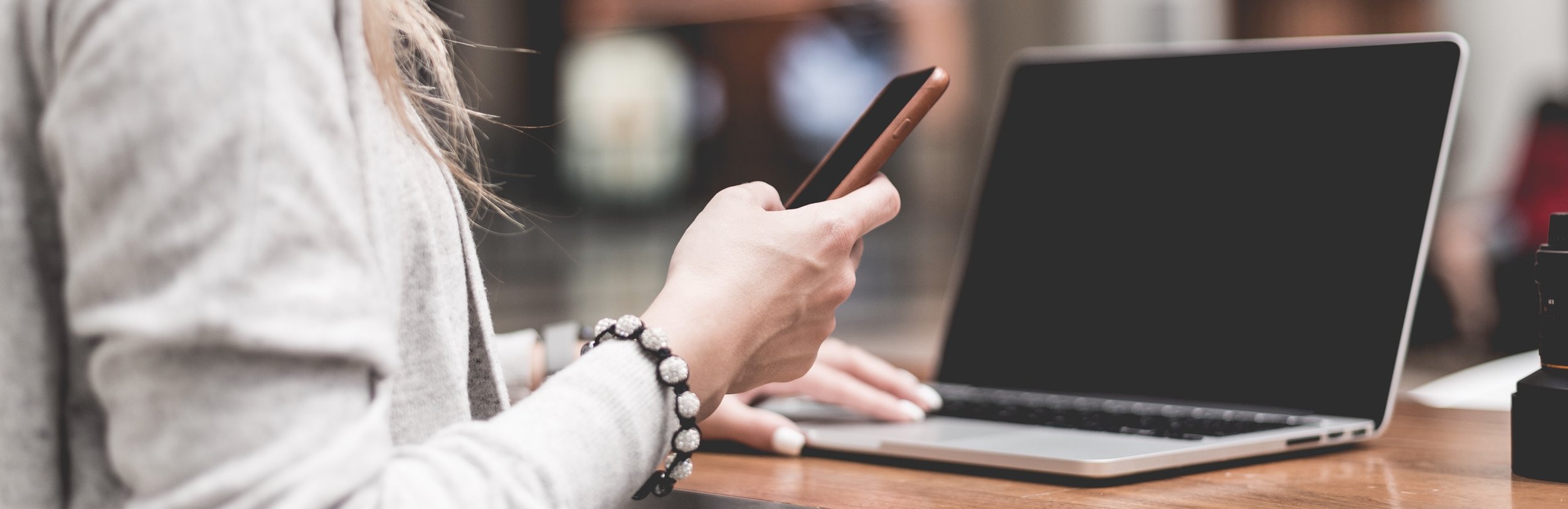 woman-using-her-smartphone-while-working-remotely-on-laptop-picjumbo-com 2.jpg