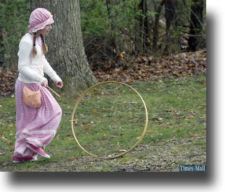 A child reinactor plays with a hoop and stick. (Photo courtesy of the Bedford Times-Mail.)