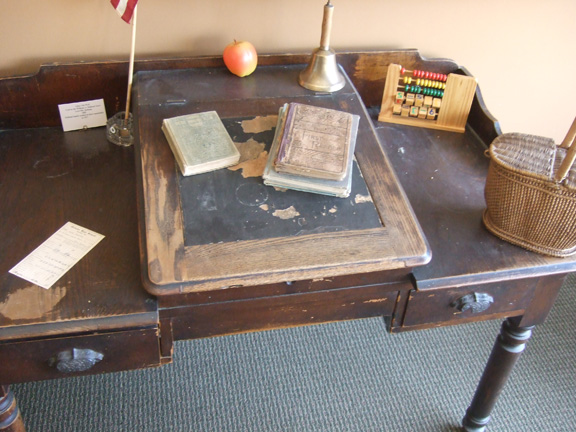  The teacher's desk was used in Bedford High School by Mrs. Hockersmith. The abacus is a reproduction of similar tools used &nbsp;to help students learn to count. A school bell on the desk would have been wrung to bring students to attention. The gla