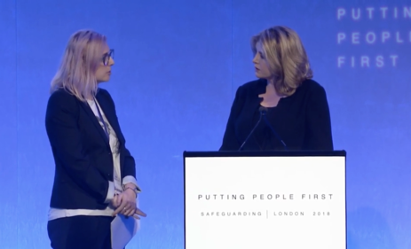 Alexia Pepper de Caires (left) delivers remarks during UK Minister Penny Mordaunt’s keynote speech at the International Safeguarding Summit. (Photo: Screenshot of DFID International Safeguarding Summit)
