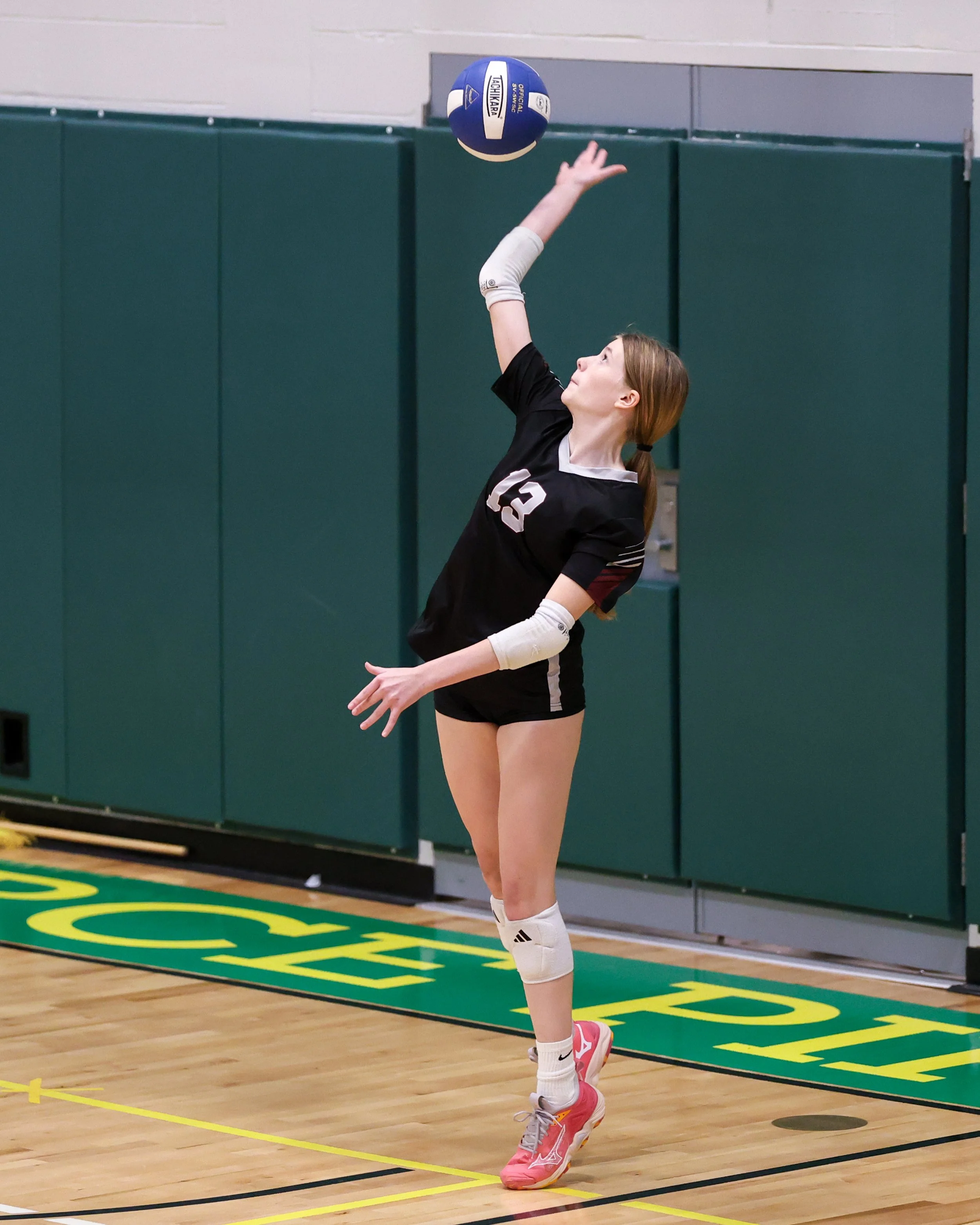 Mason girl serves the ball