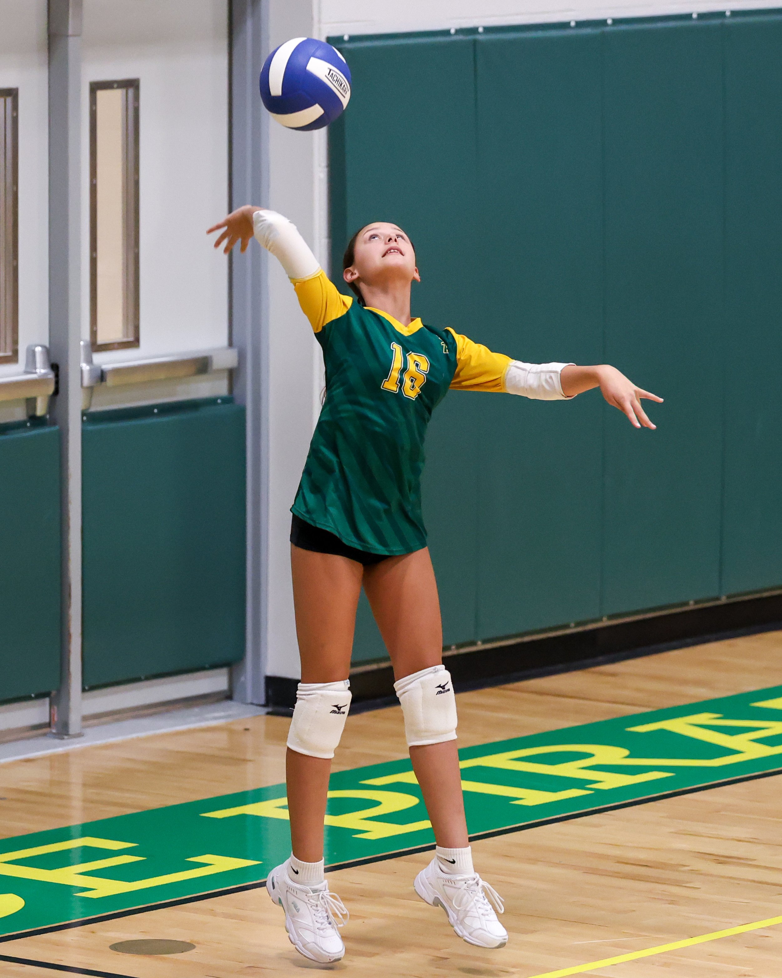 Pierce girl serves the ball