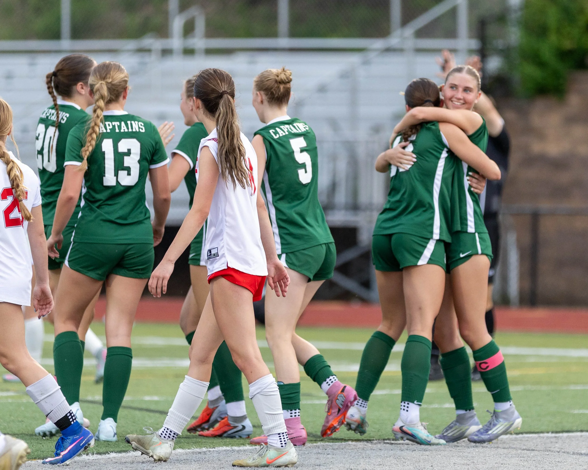 #10 celebrates a goal with a teammate