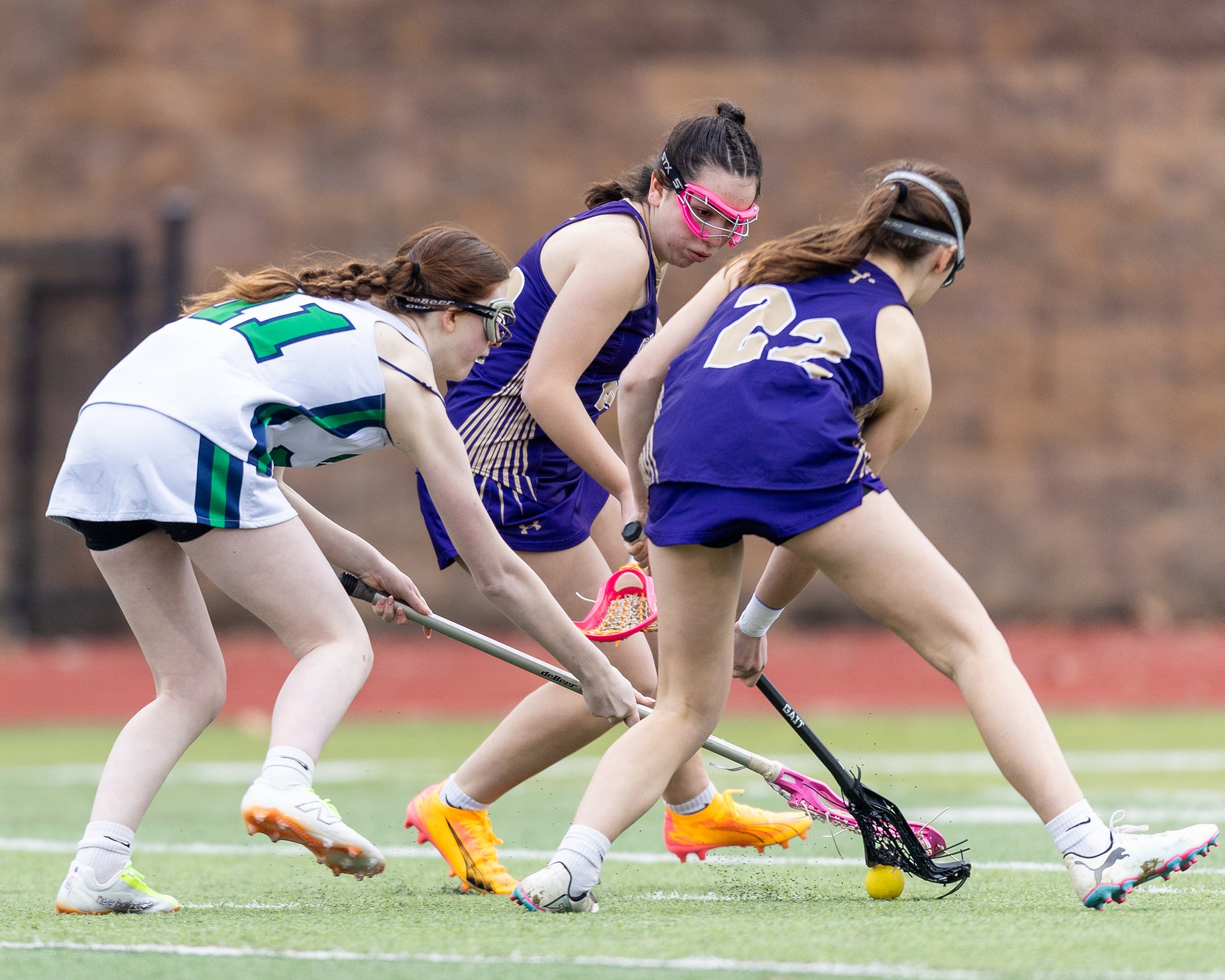 #11 tries to pick up the ball with two defenders