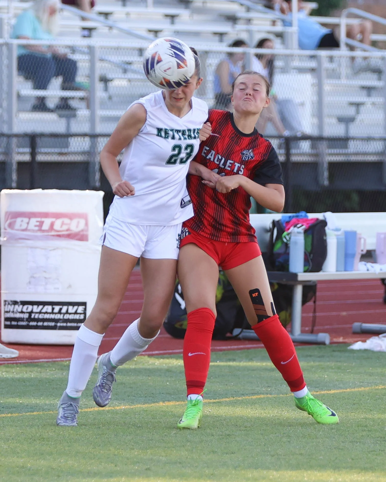 #23 heads the ball against a defender