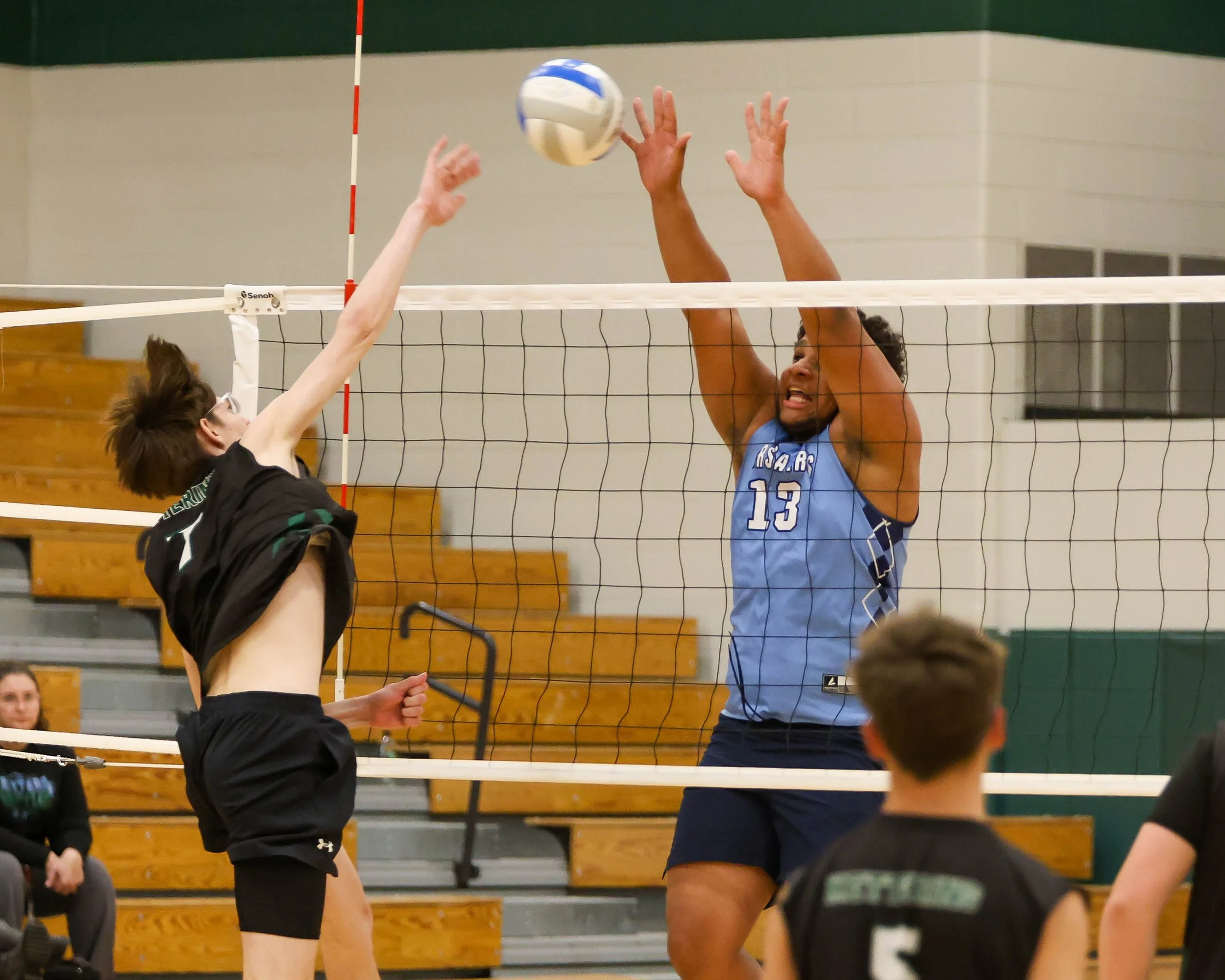 Kettering #7 spikes the ball while Mott #13 goes for the block