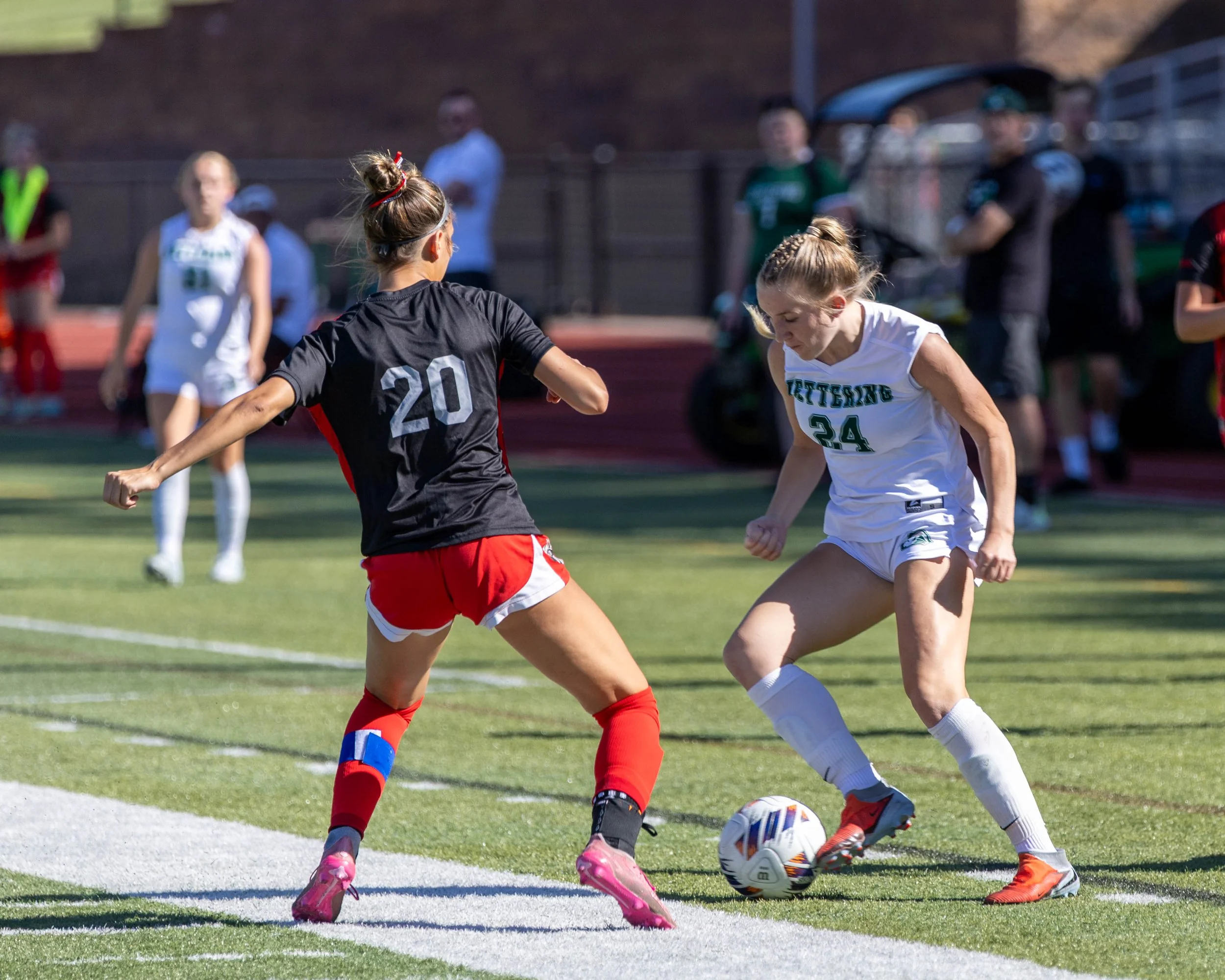 #24 controls the ball with an opponent 