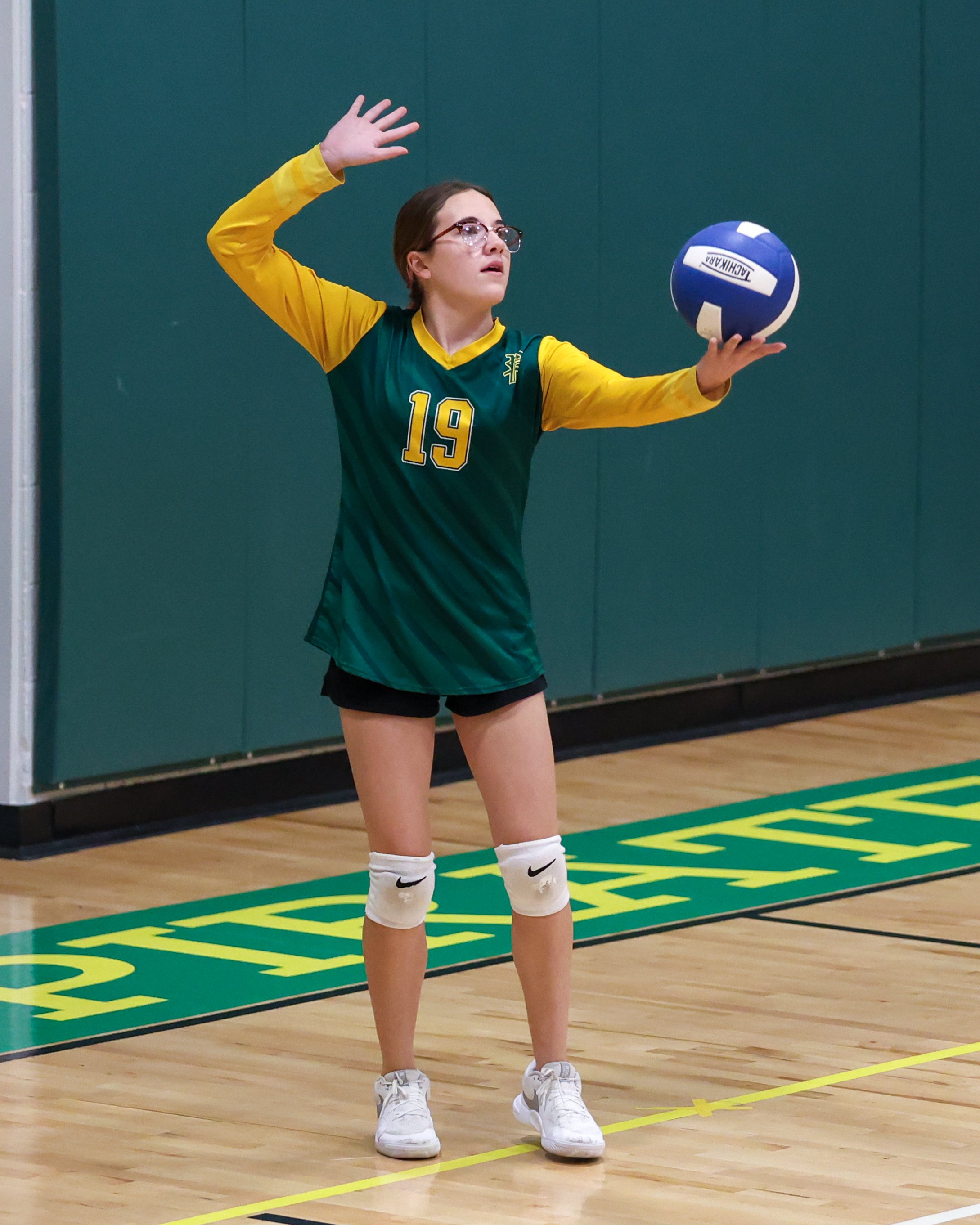 Pierce girl serves the ball