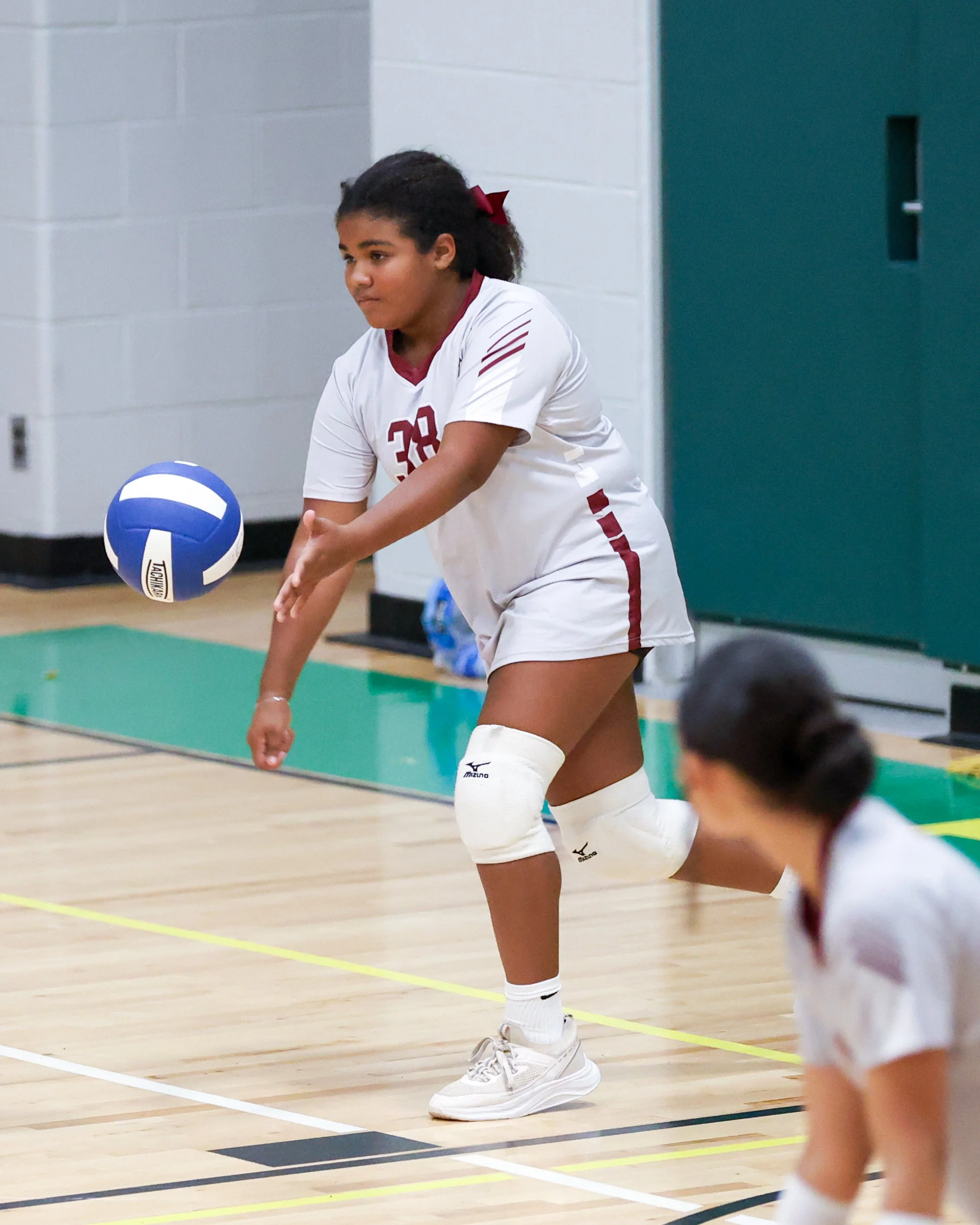Mason girl serves the ball