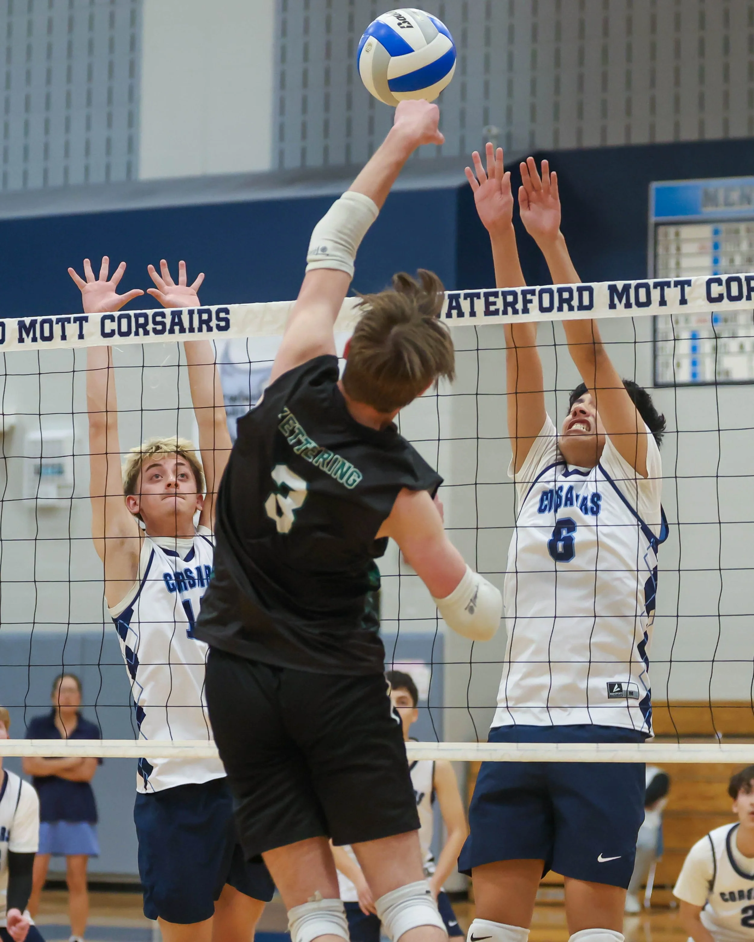 Kettering #3 spikes the ball Mott#6 and #12 try to block the ball
