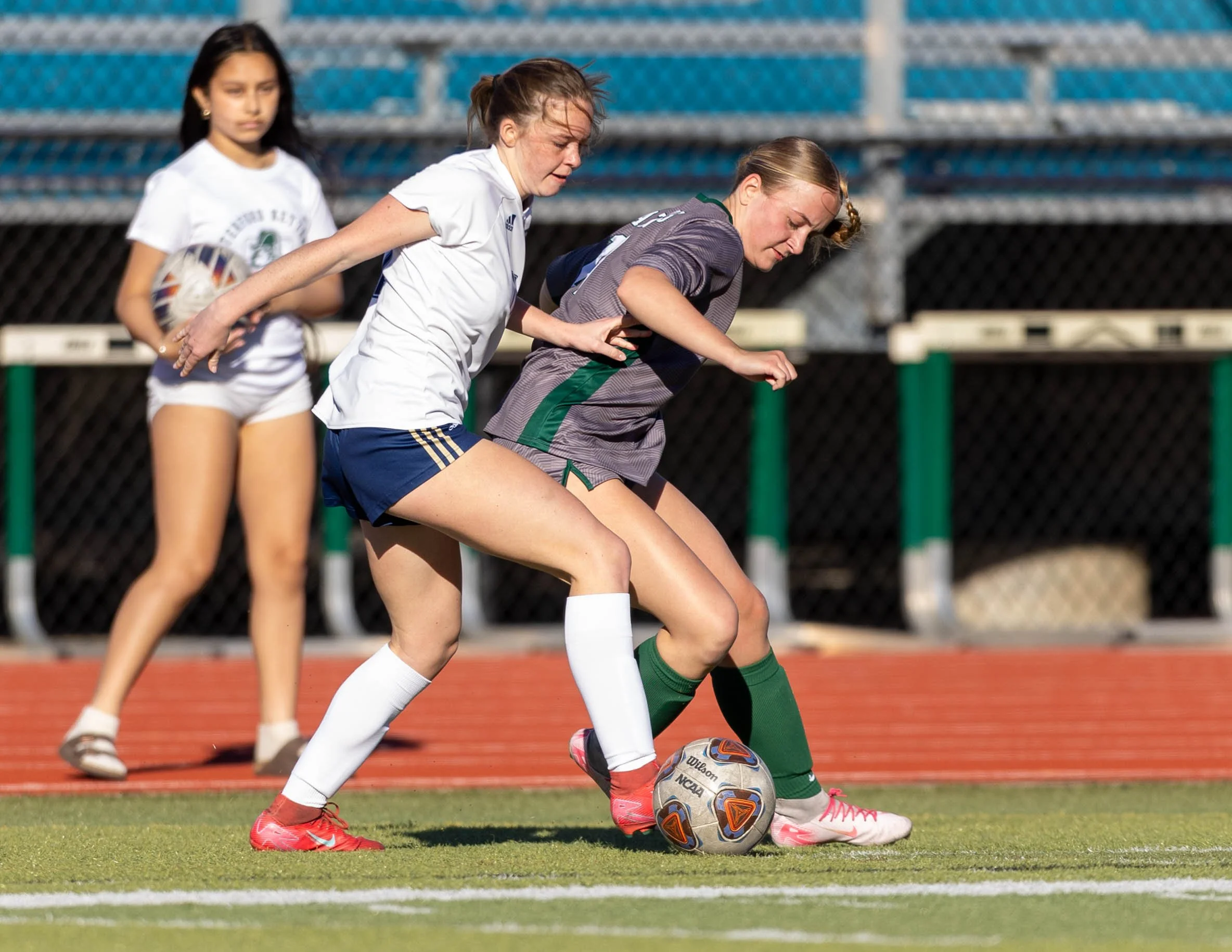 #13 fights for control of the ball with DCC player