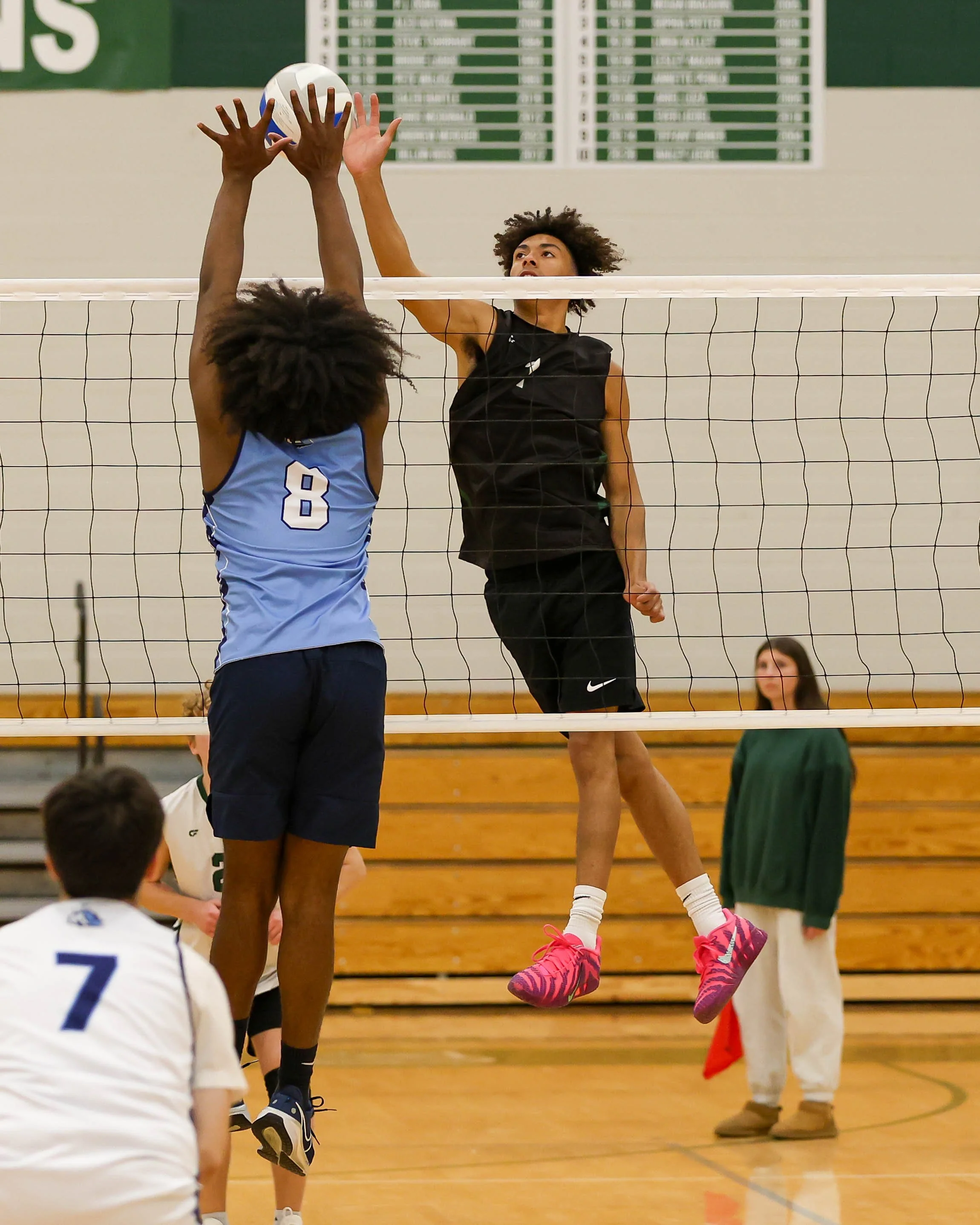 Kettering #1` hits the ball over the net as Mott#8] waits for the ball