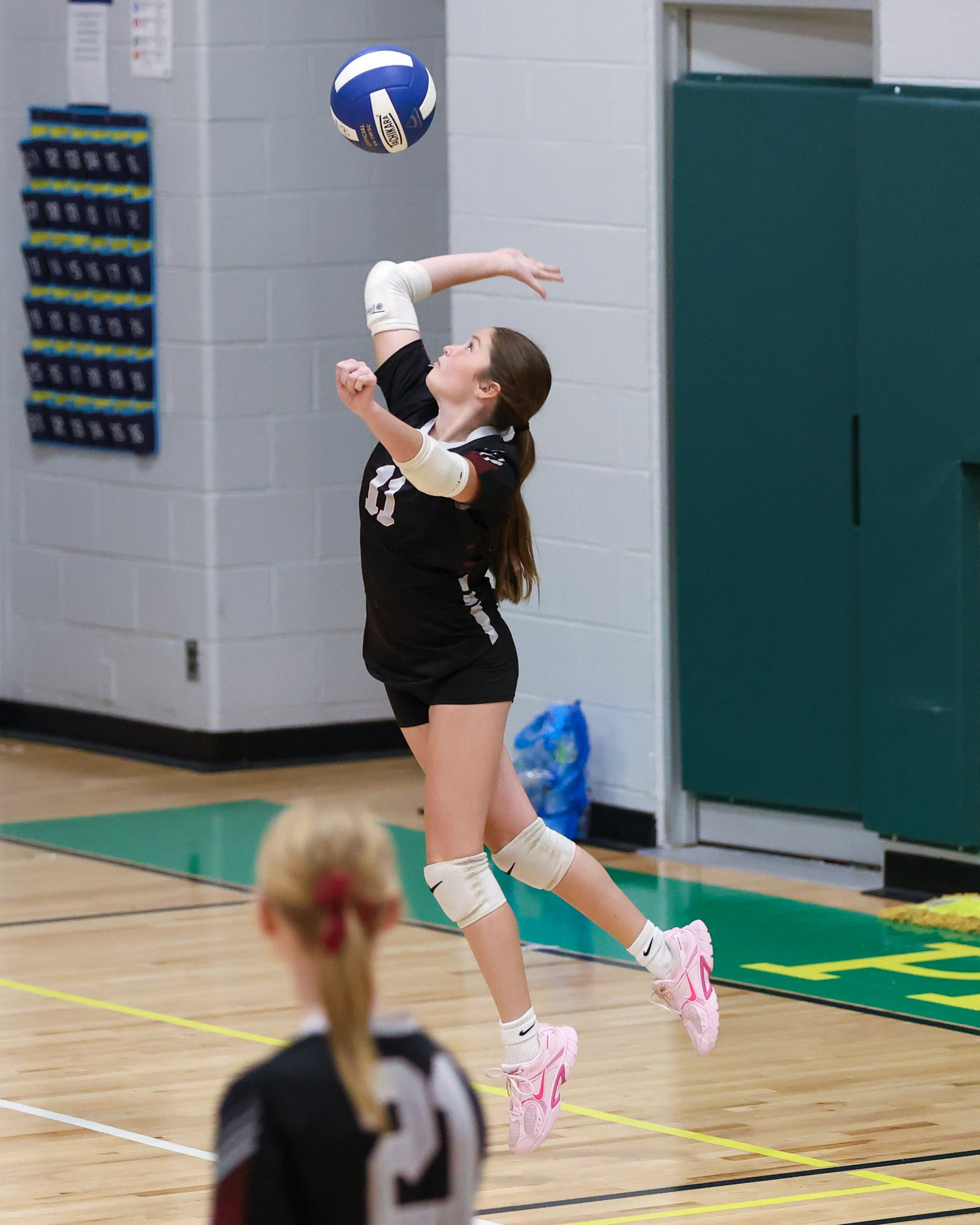 Mason girl serves the ball