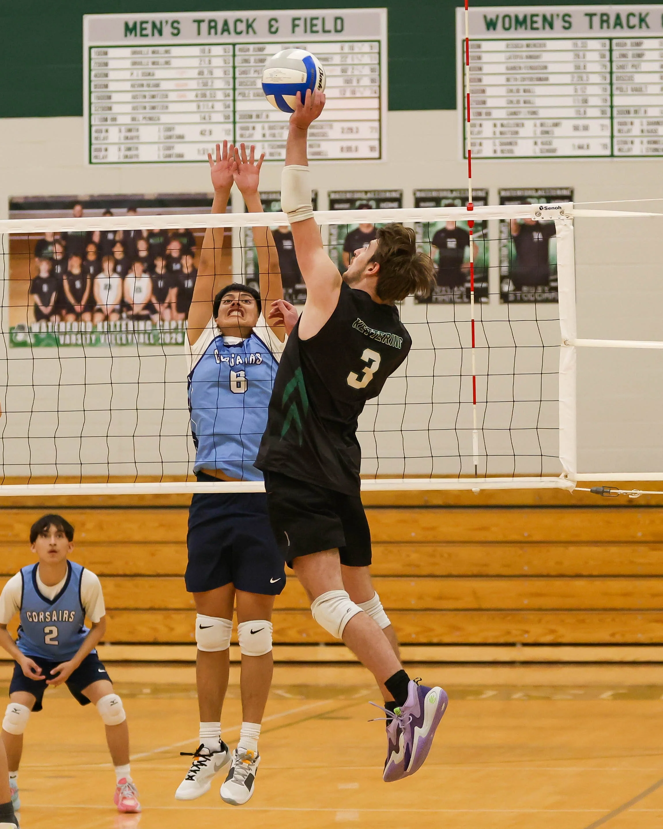 Kettering #3 hits the ball and Mott #8 goes fore the block