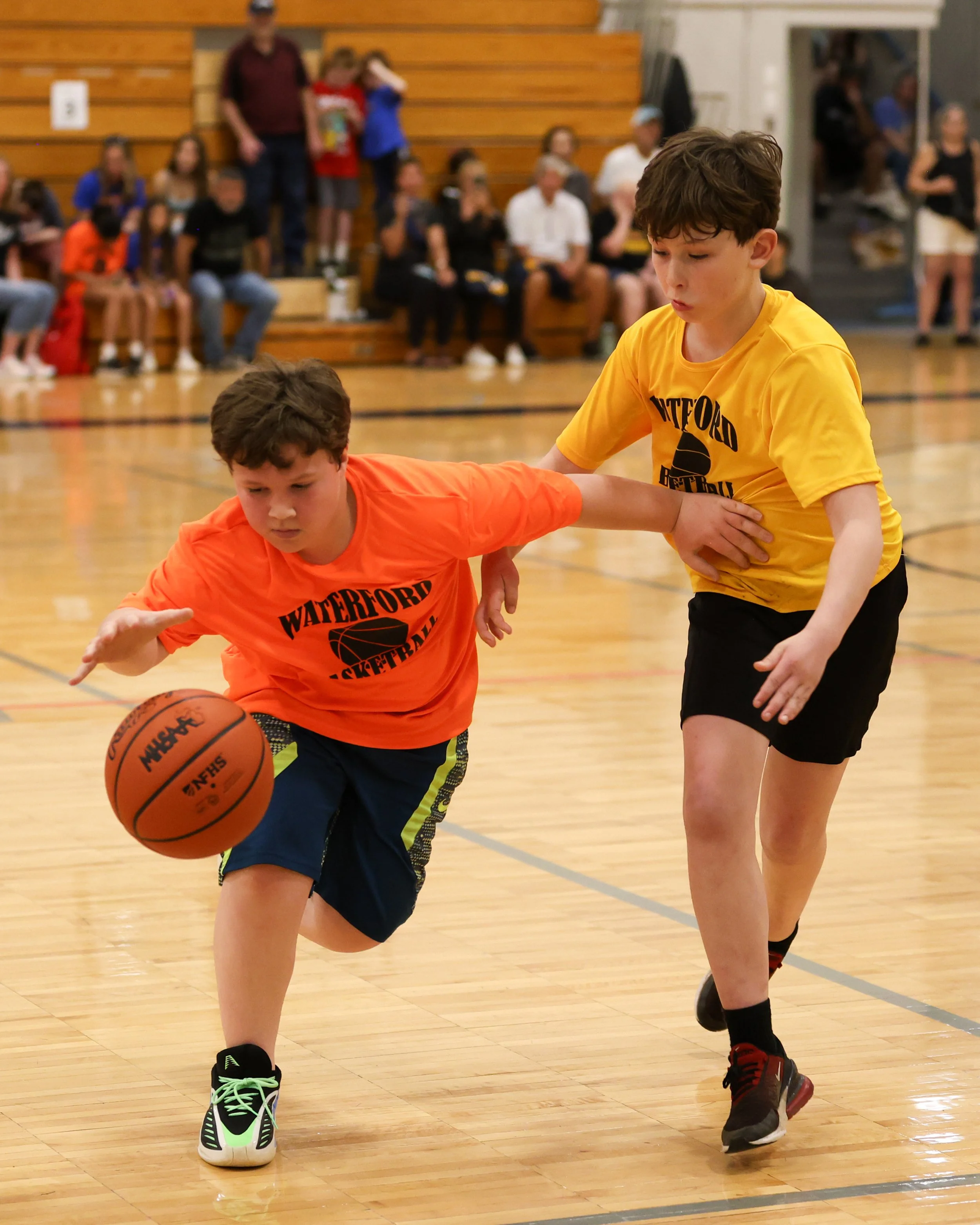 Knudsen boy dribbles ball past Schoolcraft boy