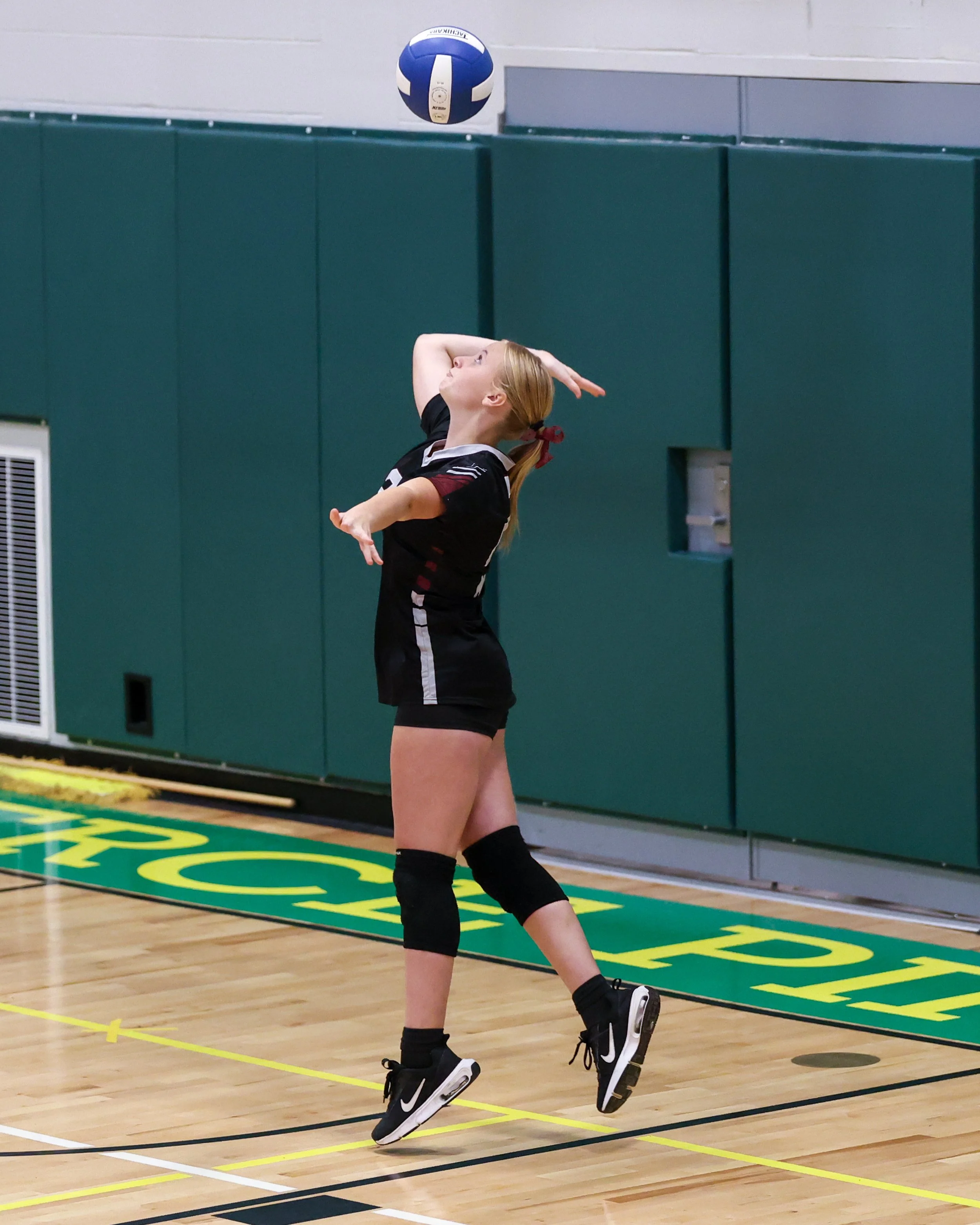 Mason girl serves the ball