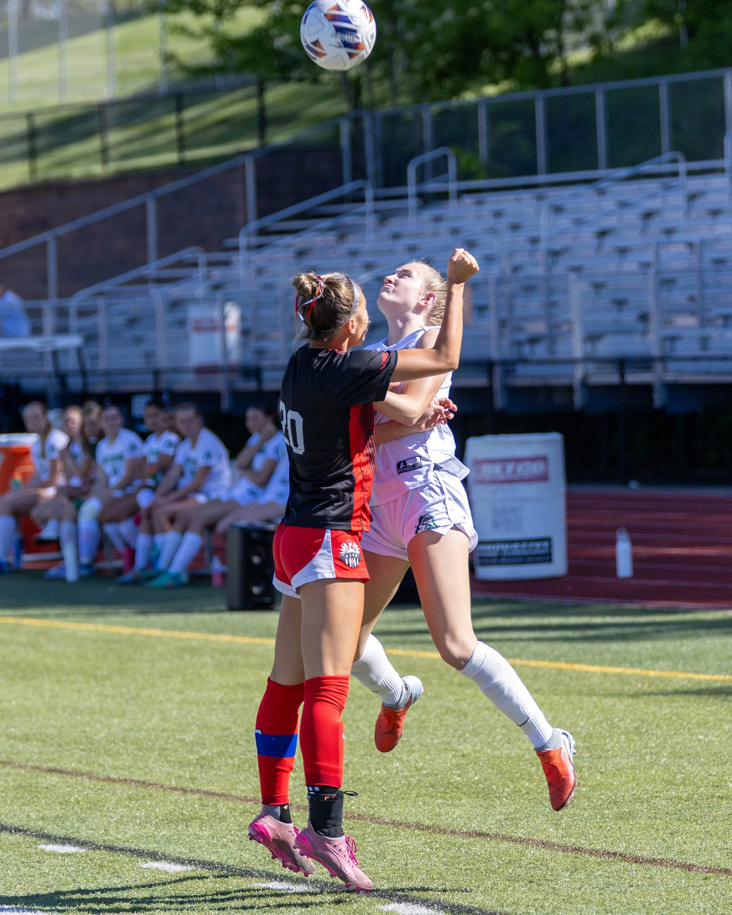 #10 heads the ball with an opponent