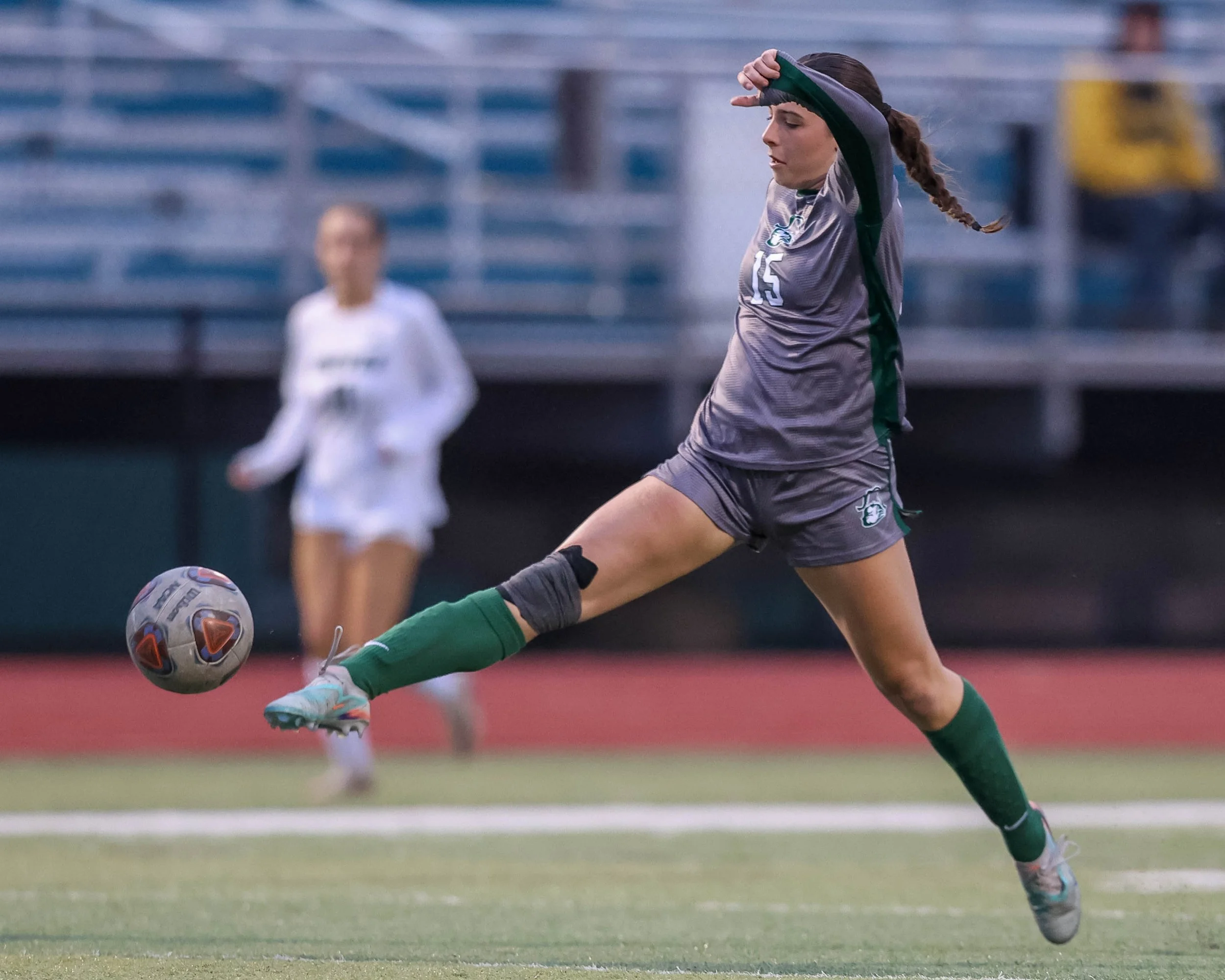 #15 reaches for the ball with her foot