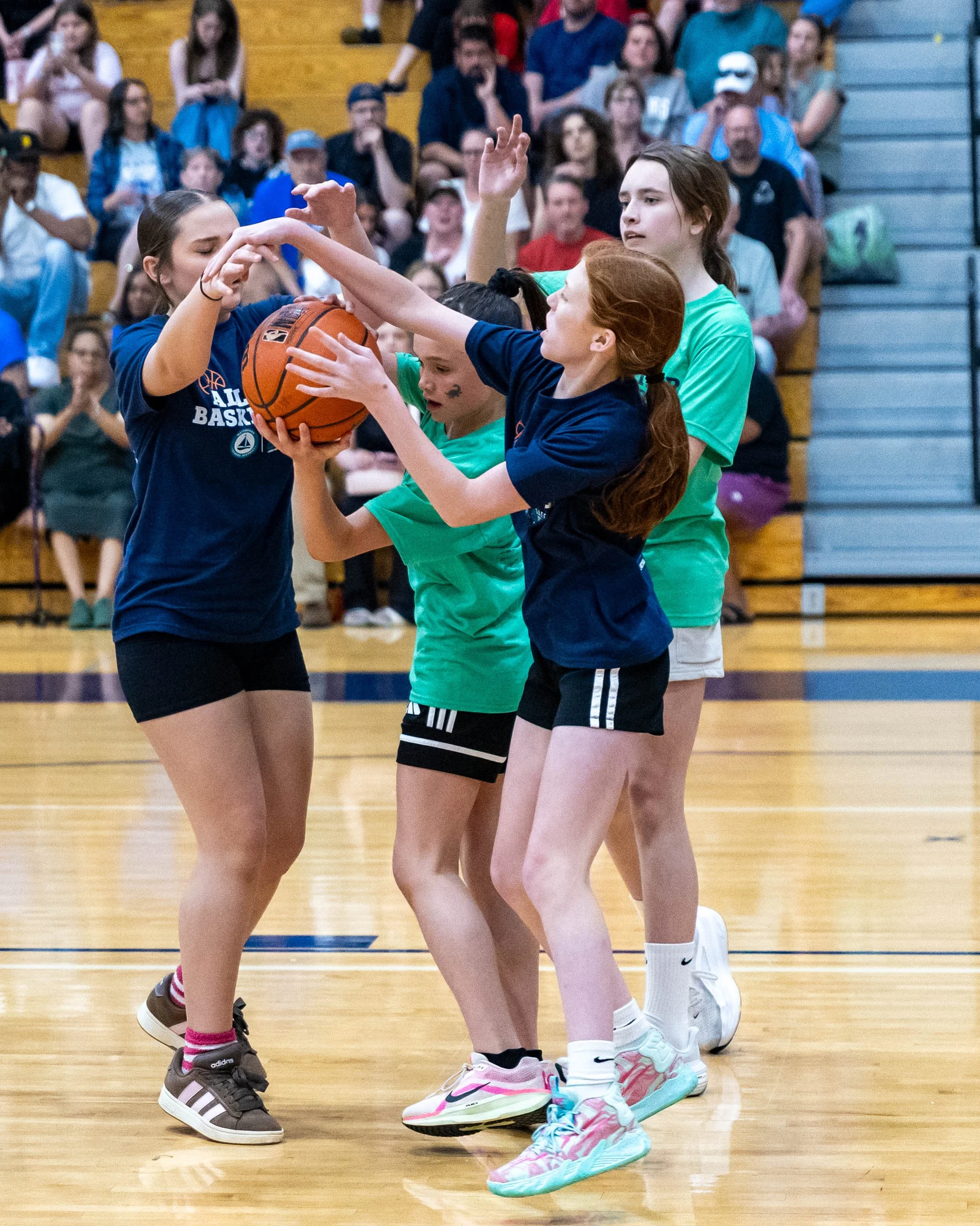 South girl holds the ball surrounded by North girls