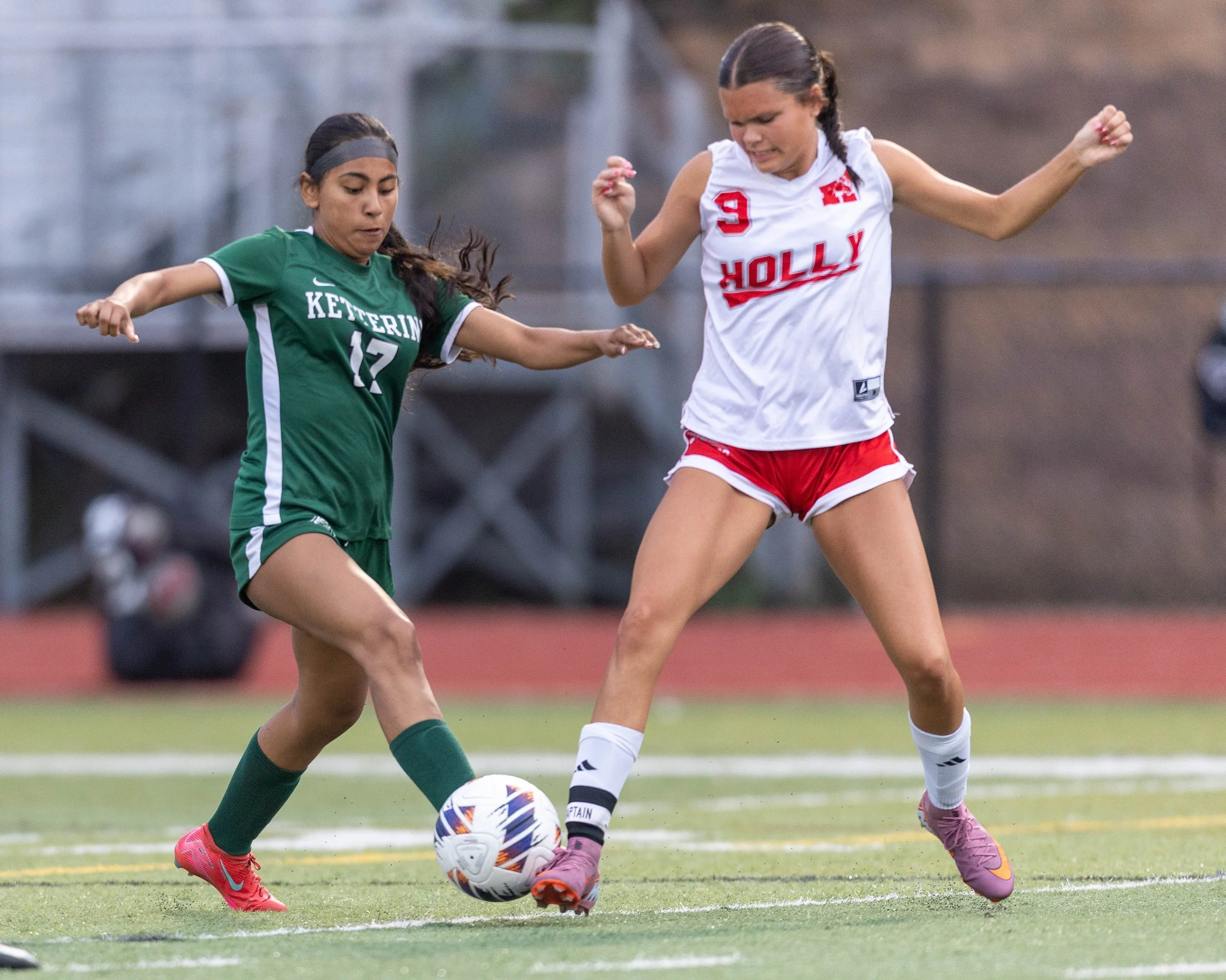 #12 fights for the ball with a defender