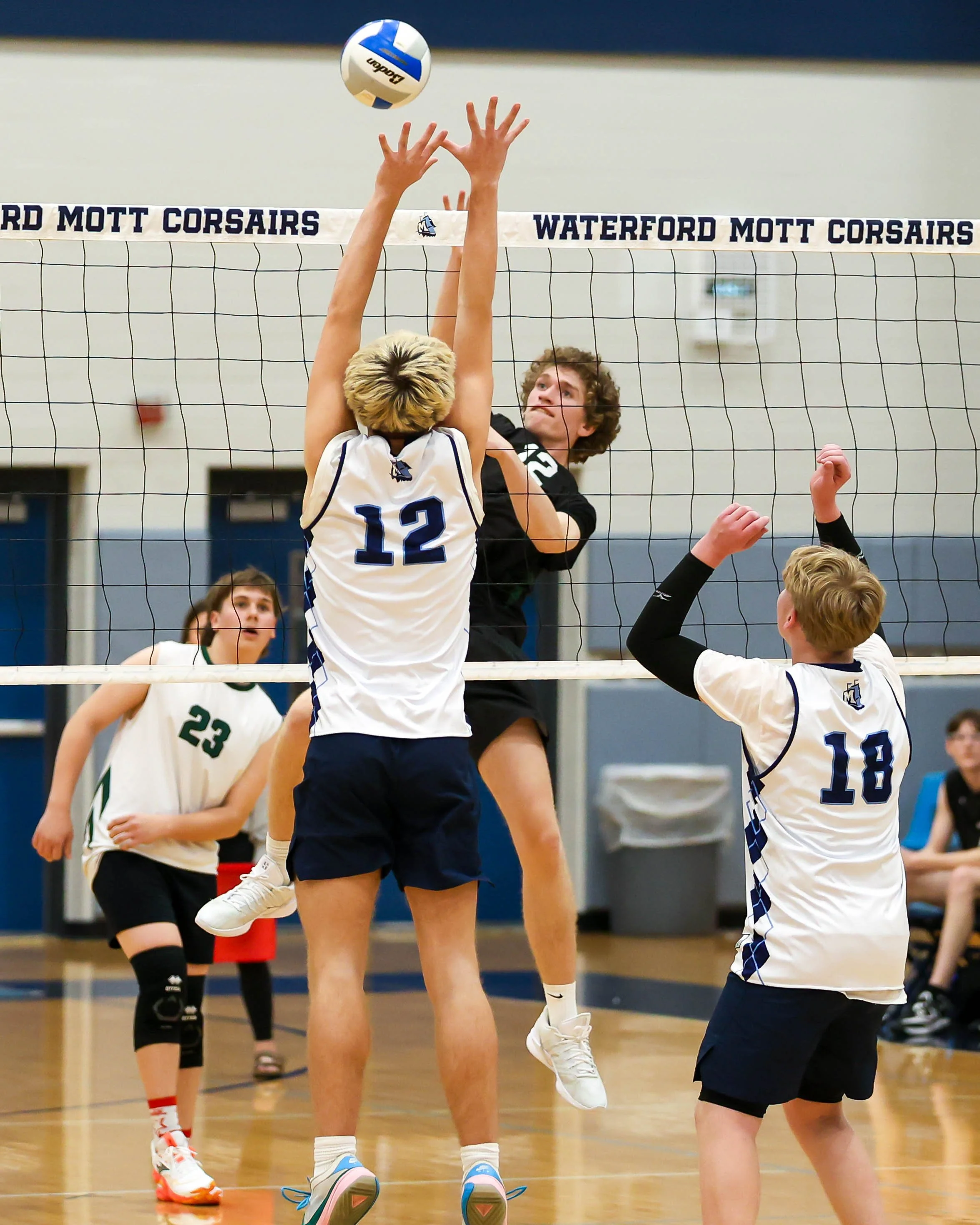 Kettering #12 spikes the ball and Mott #12 tries to block