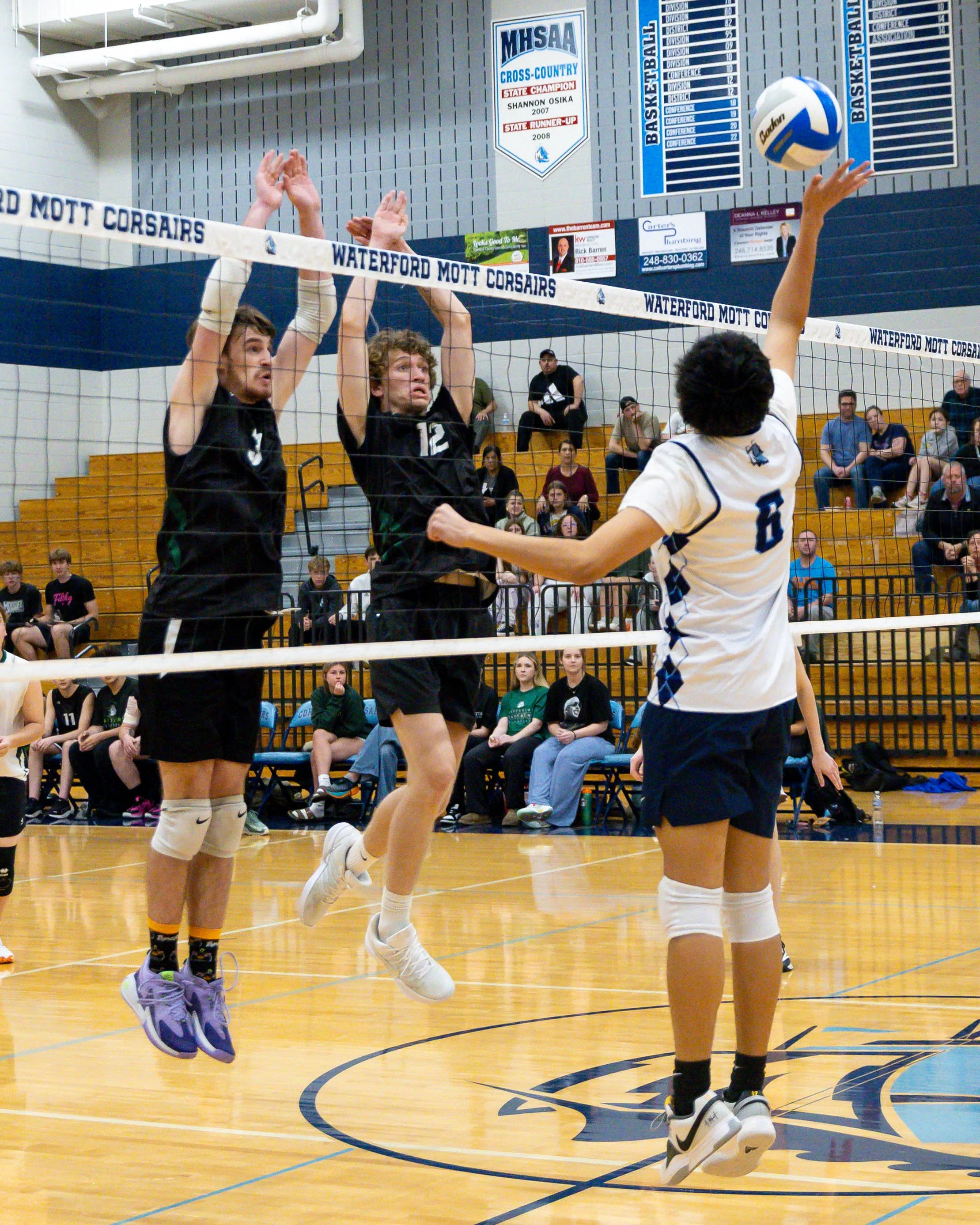 Mott # 8 returns the ball with Kettering #3 and #12 try to block