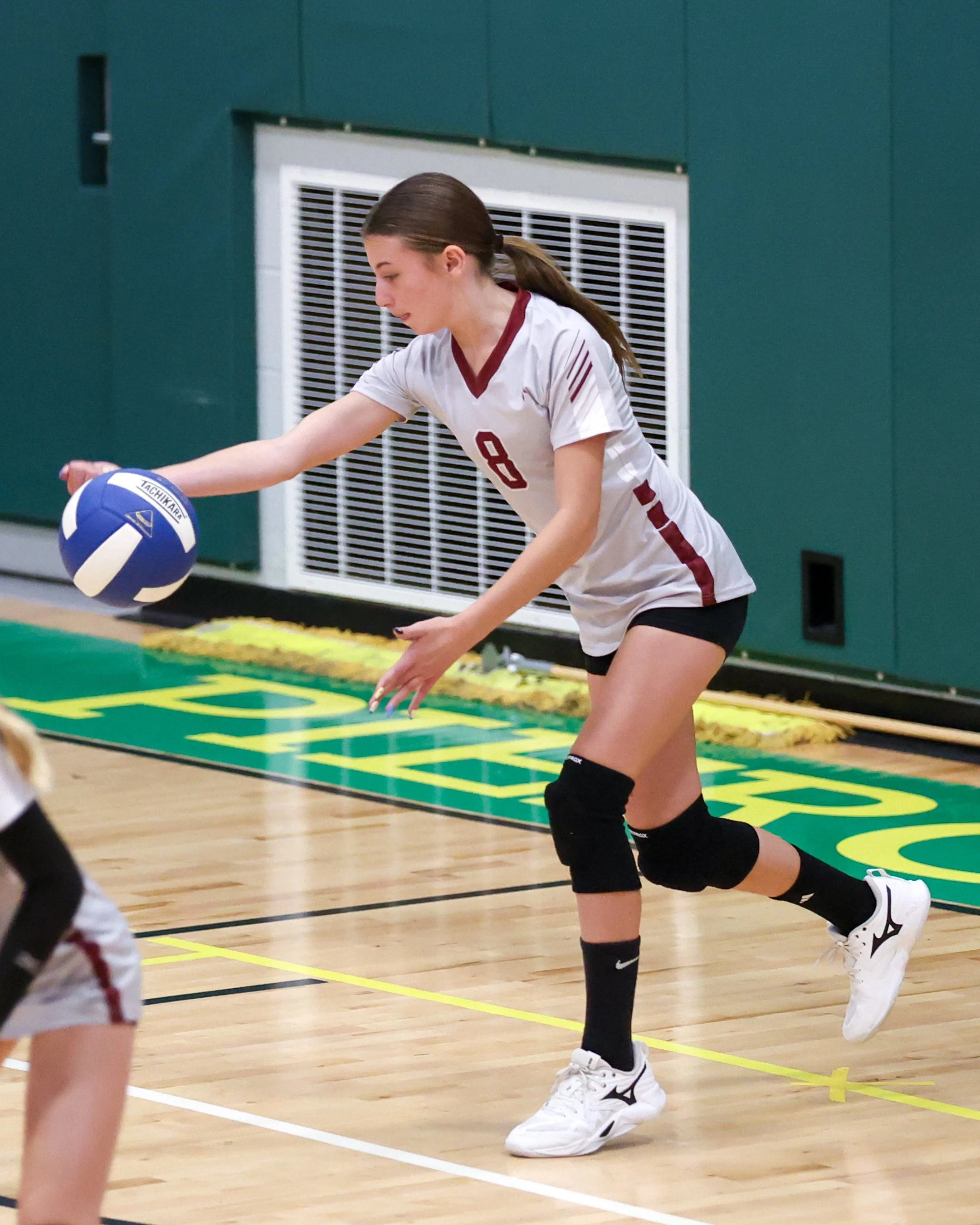 Mason girl serves the ball