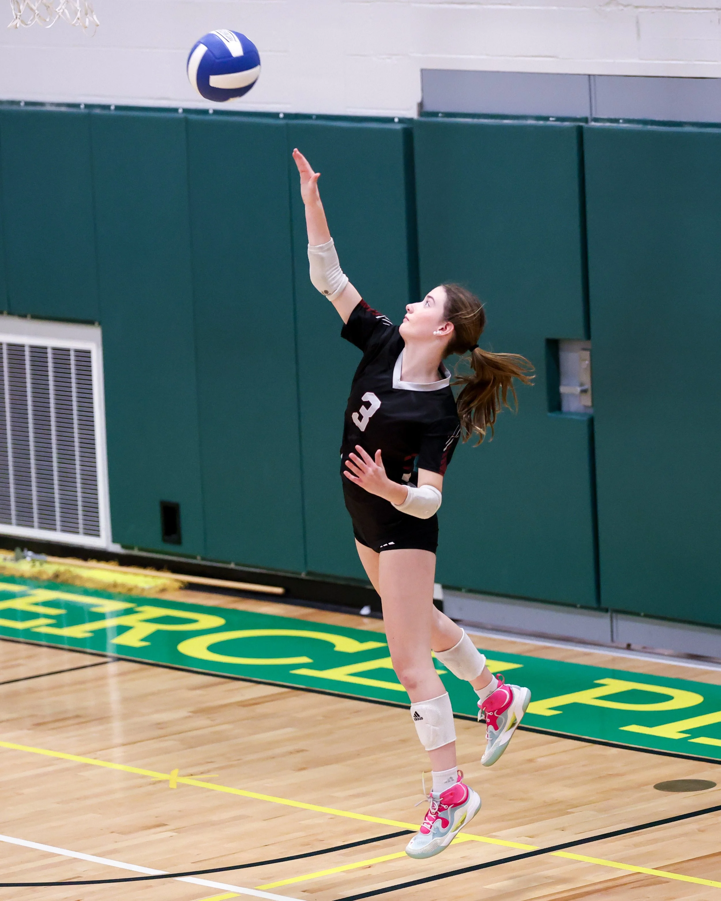 Mason girl serves the ball