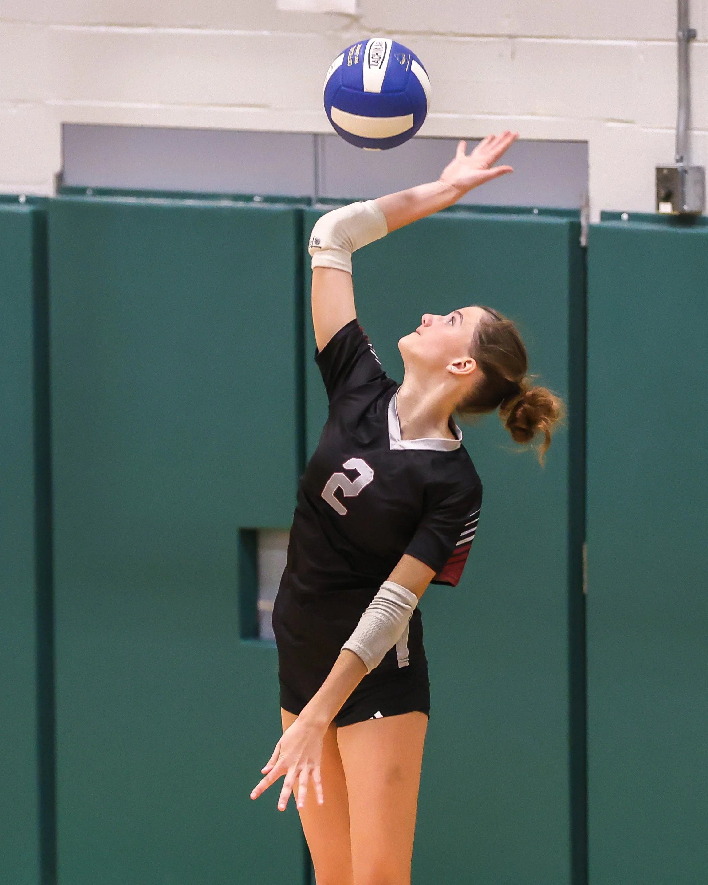 Mason girl serves the ball