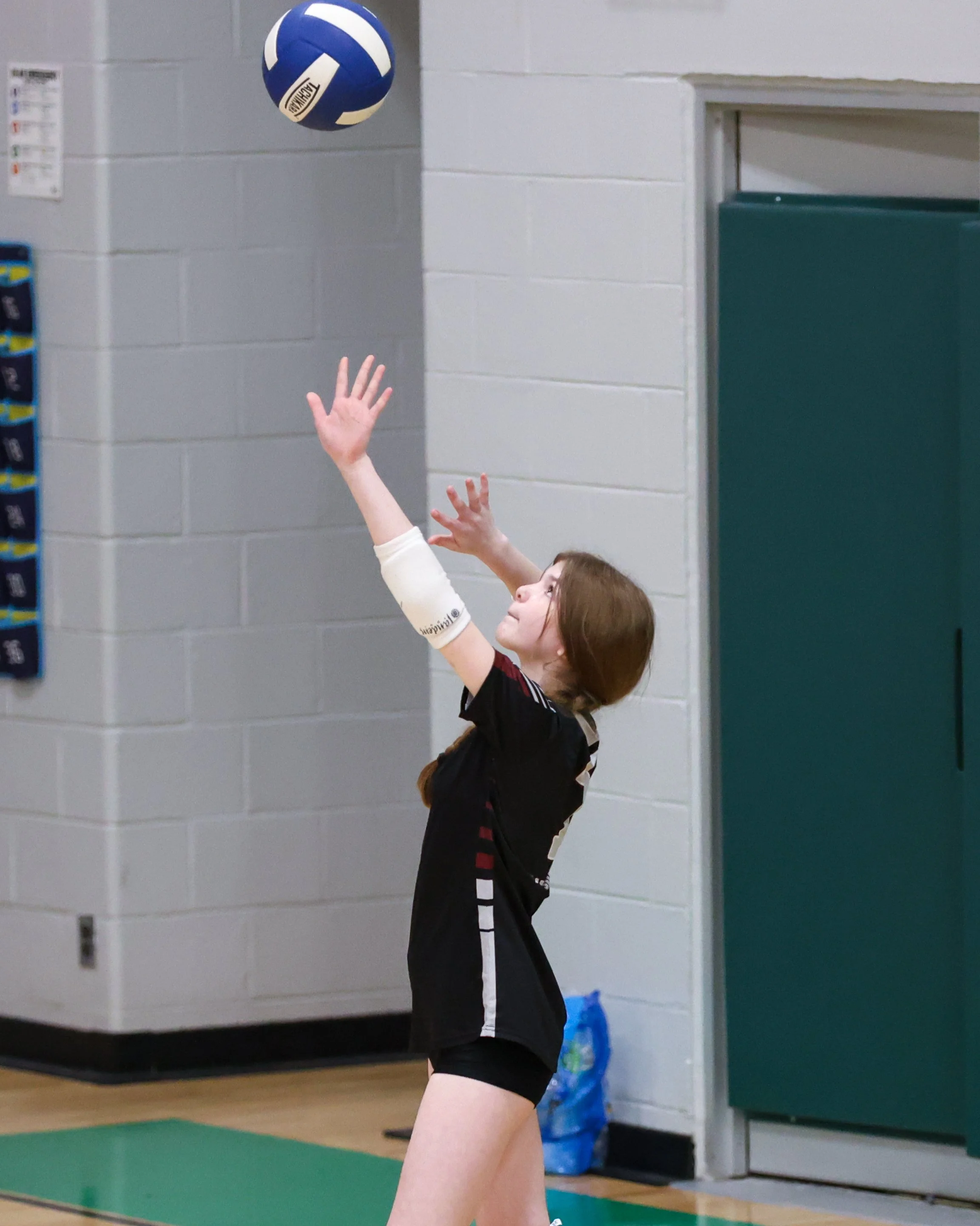 Mason girl serves the ball