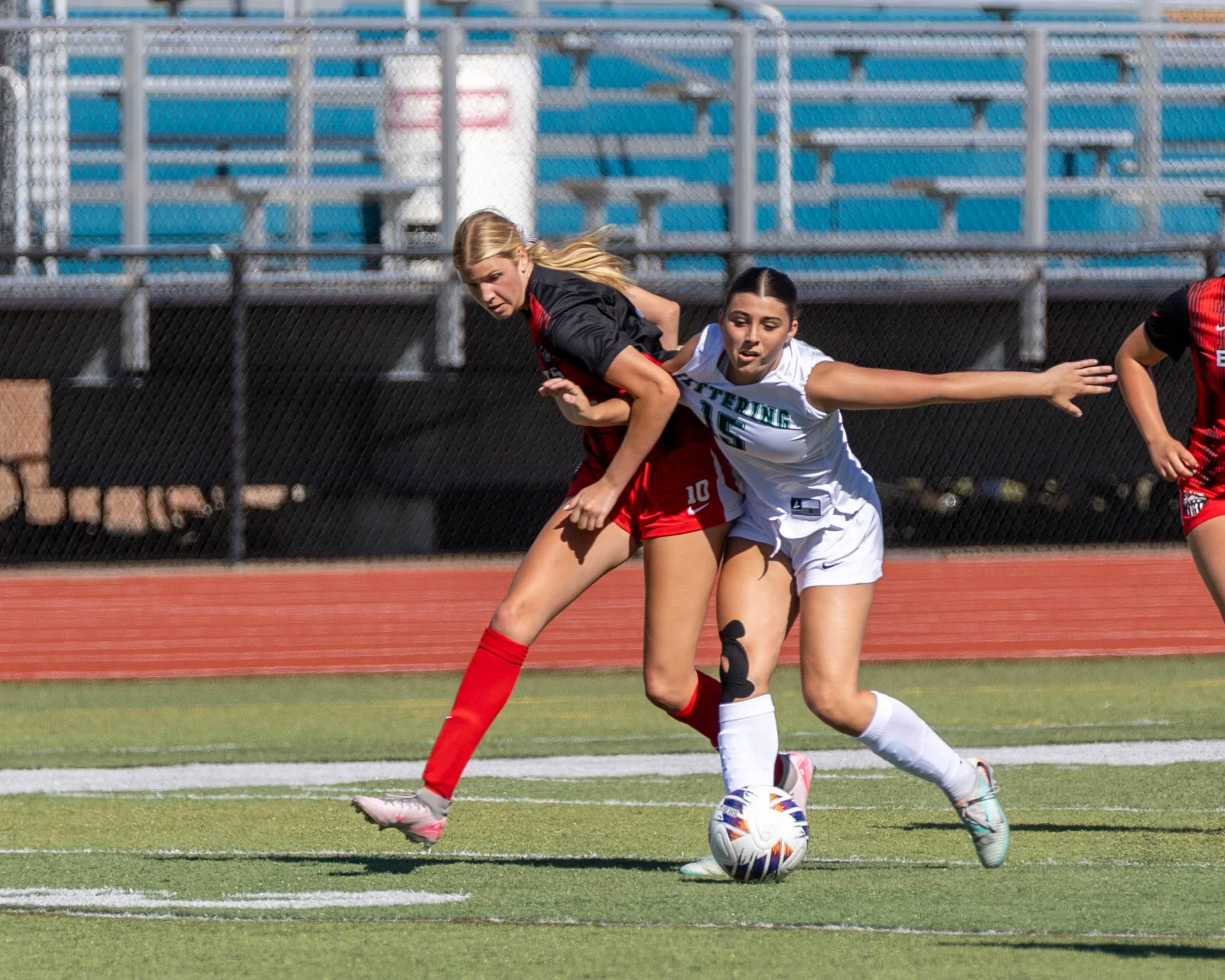 #15 fights for the ball with an opponent