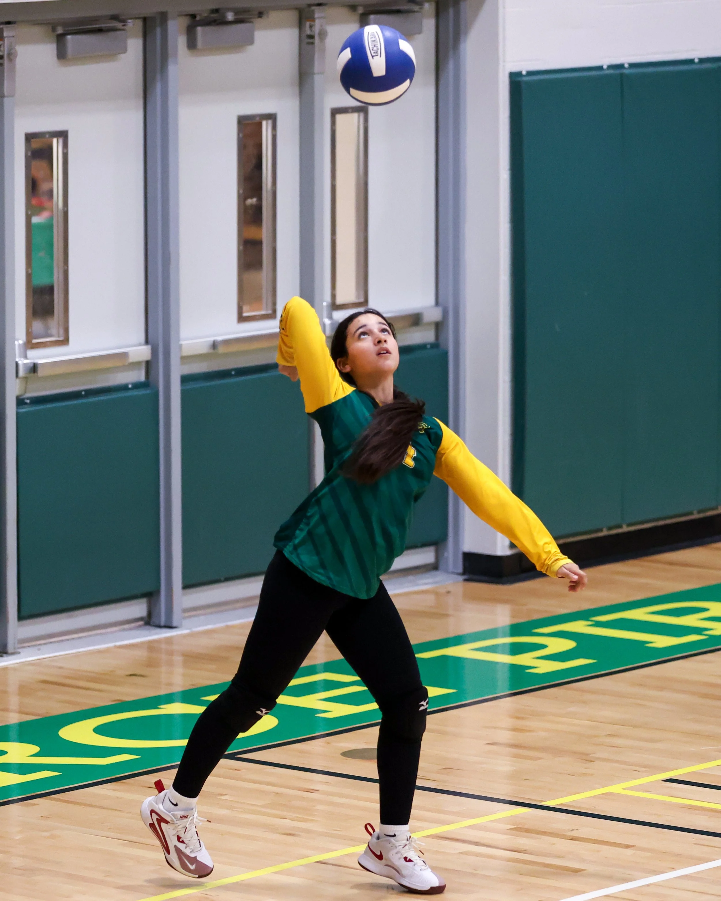 Pierce girl serves the ball