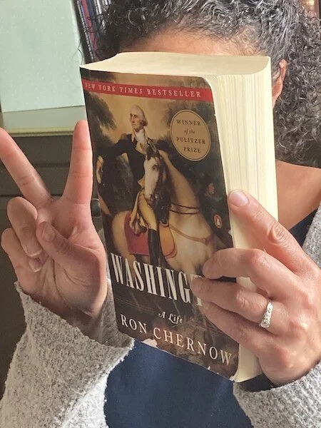 Anne holding the book Washington: A Life by Ron Chernow