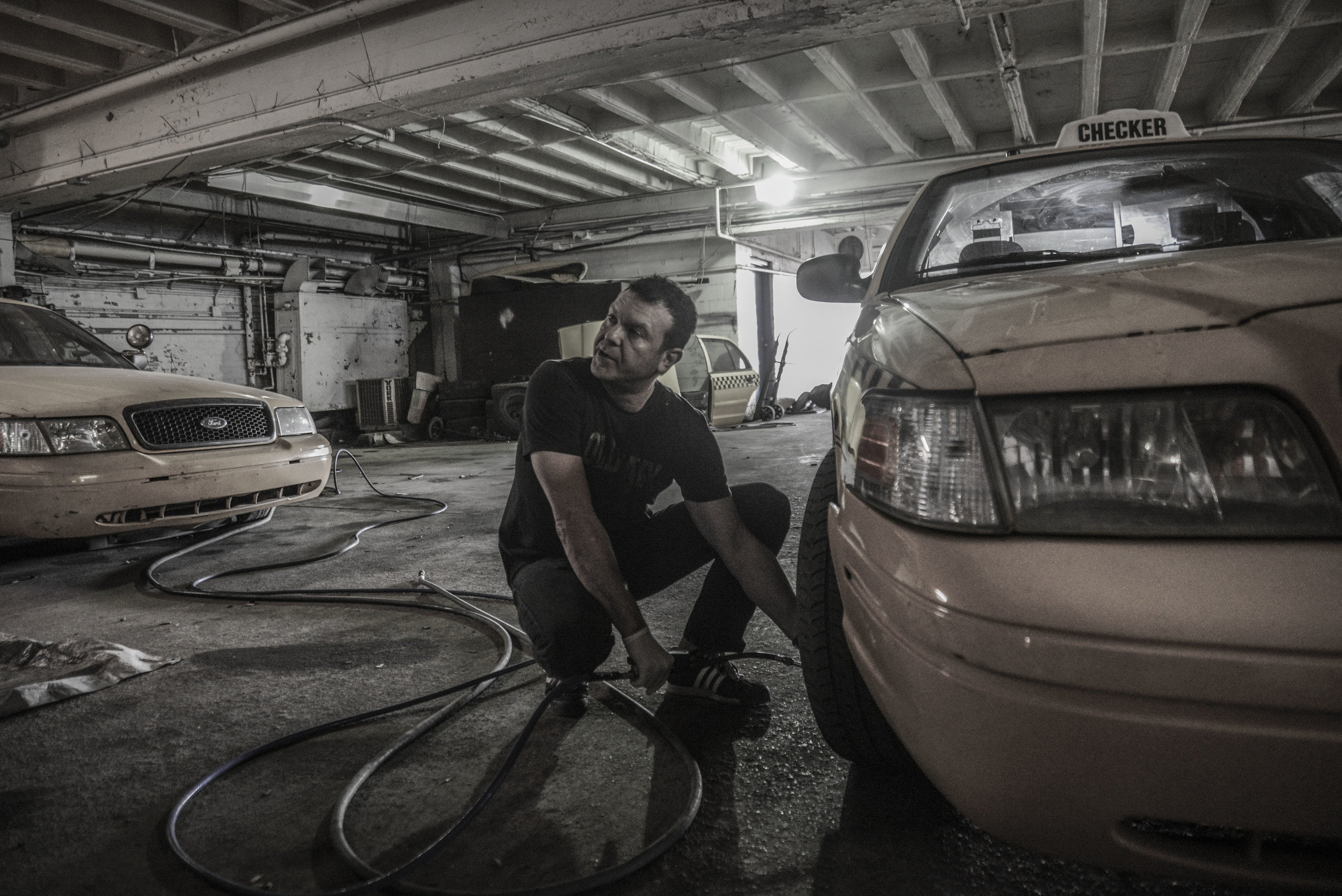  Detroit resident, Steve, 43, fills one of his cab driver's tires up with air before the driver's day of work begins, at Checkers Cab Company.&nbsp;“I started my cab company in 2010 with three cars out of my garage and because I was so successful wit