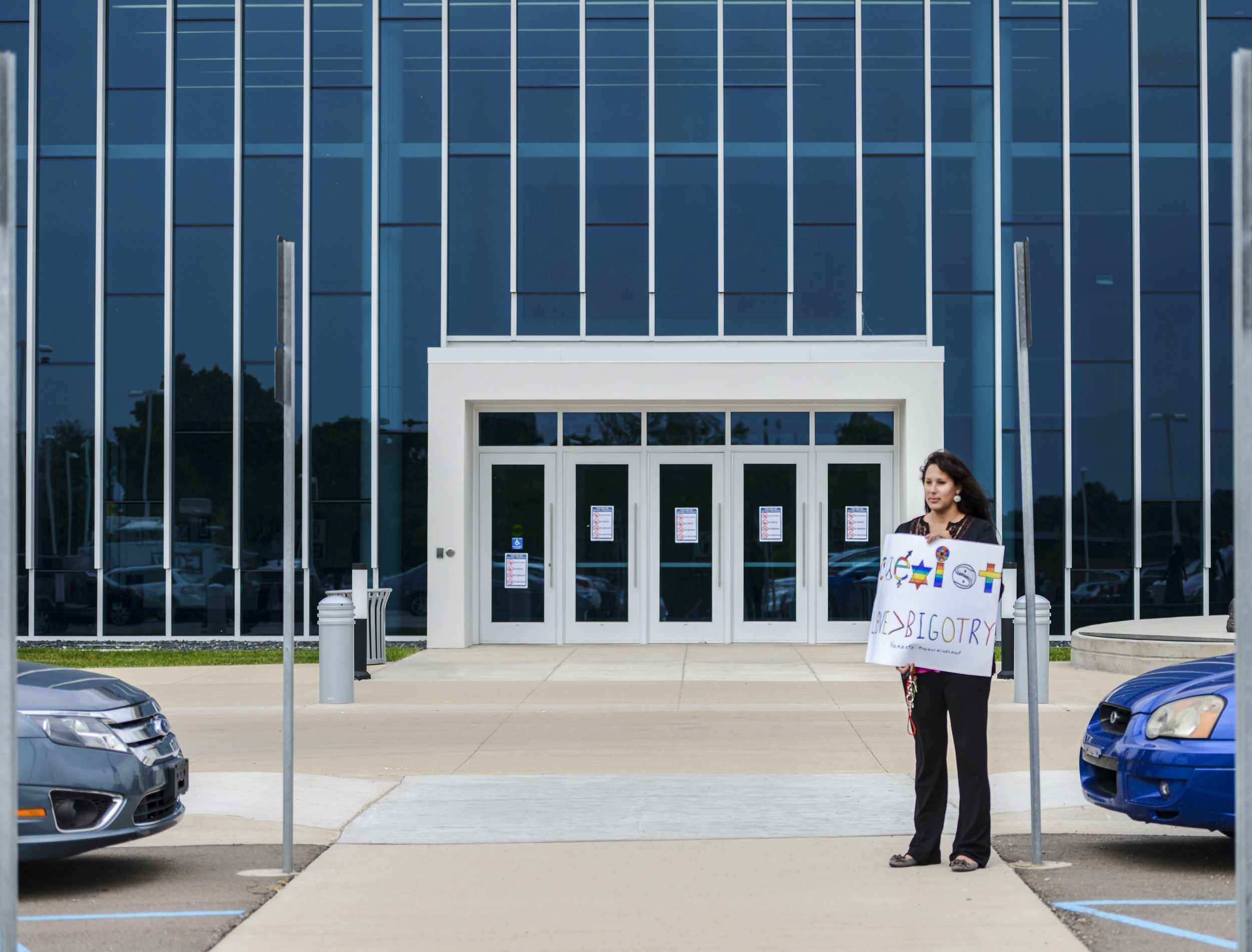  Freeport resident, Maya Esparza-Siegers, stands by the entrance of the Jenison Center for the Arts, with a sign during a peaceful protest towards owner of Dieseltec, Brian Klawiter's event to discuss "the true state of the Union" Thursday, June 11, 