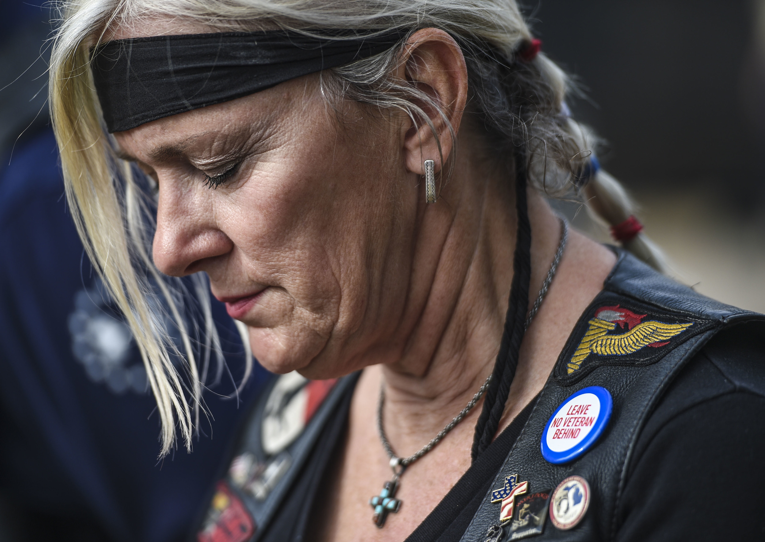 Deb VanderHoff, member of the Patriot Guard Motorcade, bows her head in prayer after police and fire agencies raise the flag to honor Wounded Warriors, at the Gerald R. Ford Presidential Museum Thursday, Sept. 10, 2015, in Grand Rapids, Mich.