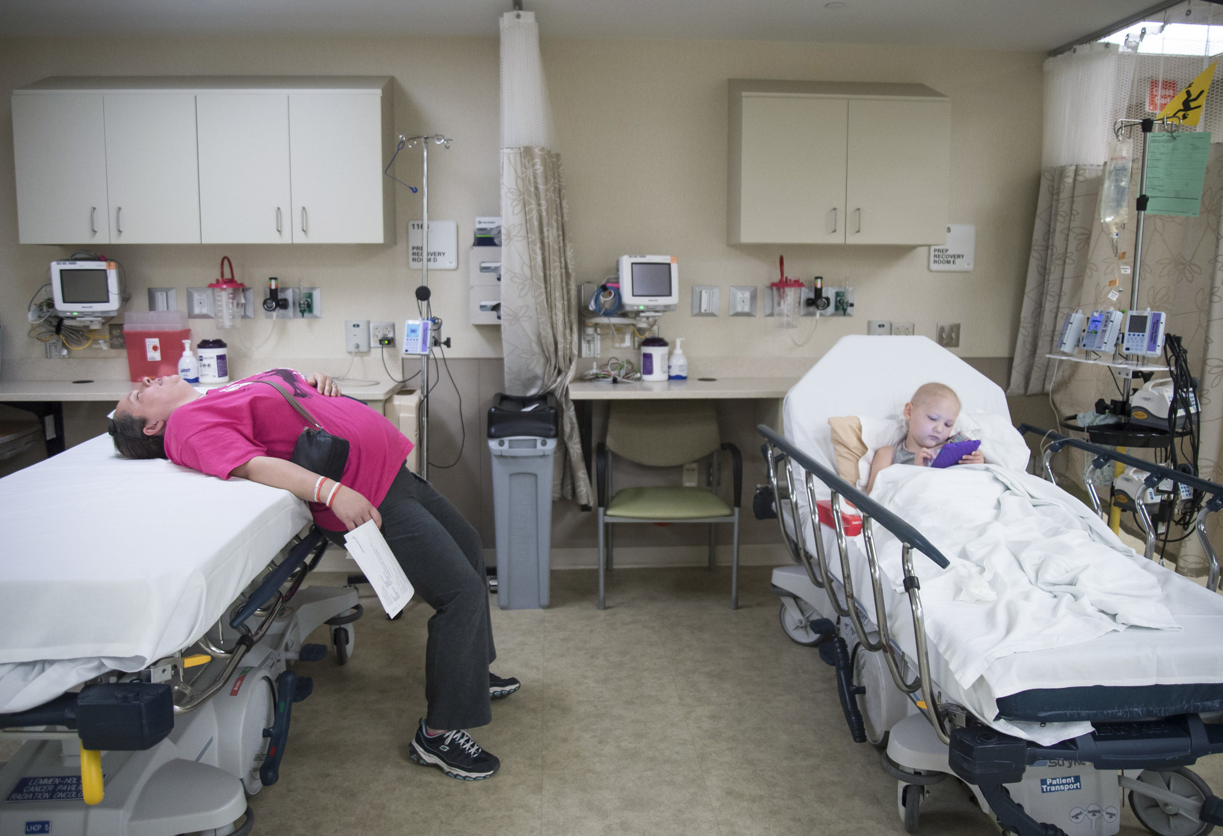  Naomi's mother, Donna Norton, lies on a bed across from Naomi while they wait for her radiation treatment. The stresses and worries of life had been weighing down heavy on Donna, keeping her awake at night.&nbsp; 