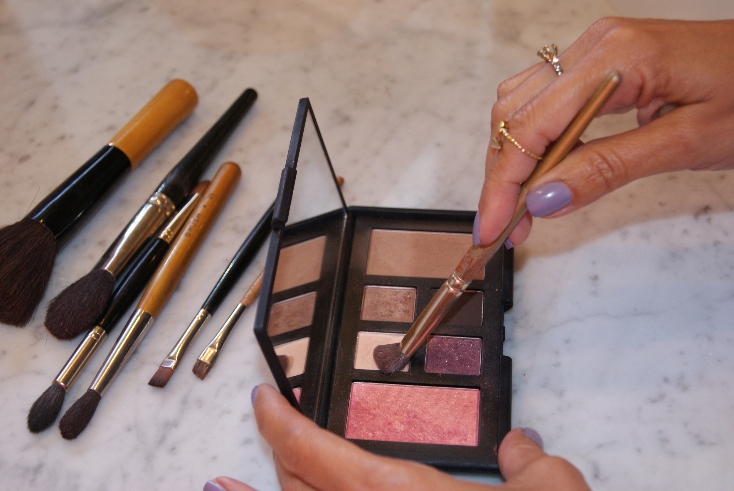 Step 2. Using a flat smaller brush, apply the sheer peach with gold pearl shade as a base and under the brow bone.&nbsp;