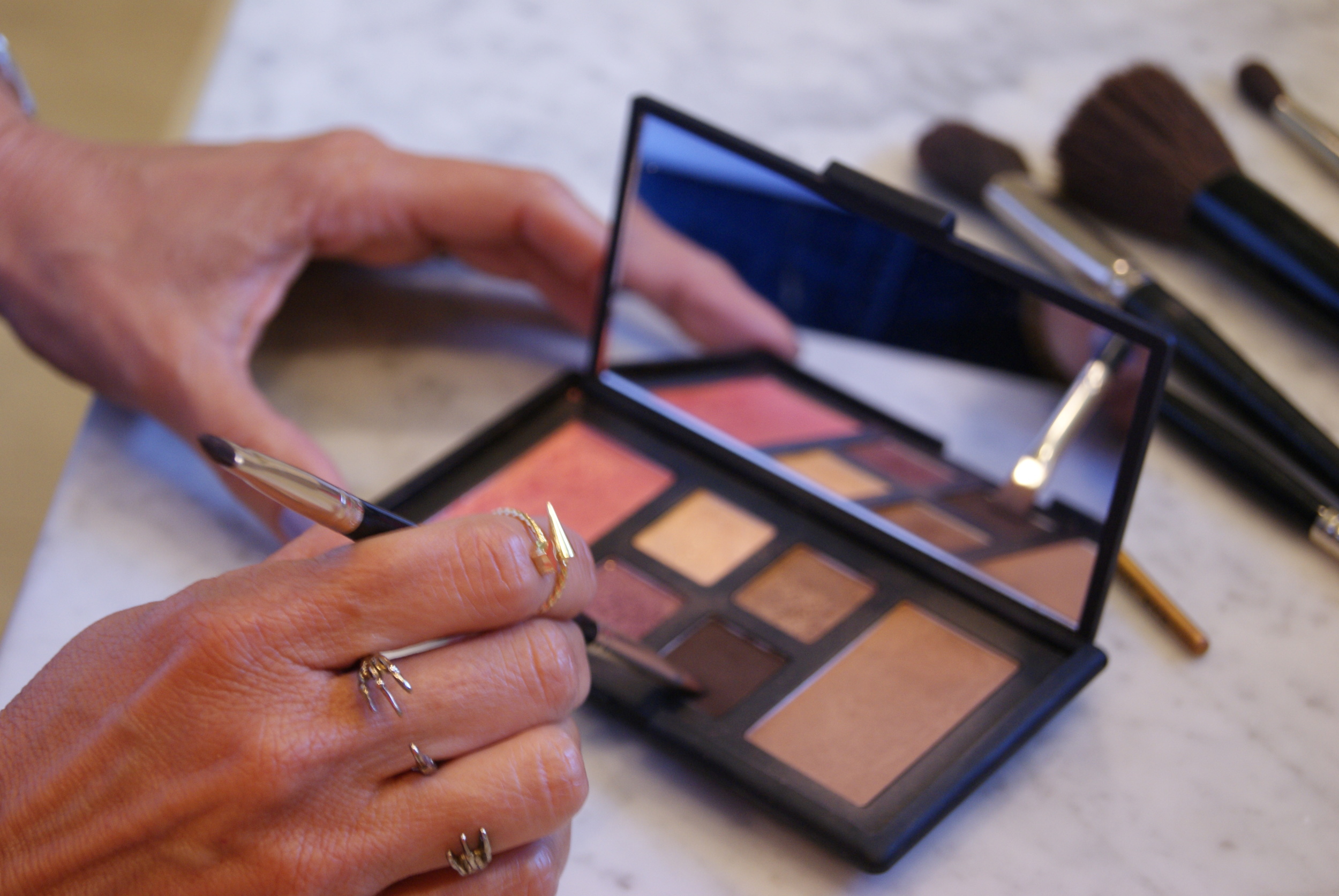 Step 5. Use a thin flat top brush and apply the deep brown shade to line the eye. Tip: You can use to fill in and enhance your eyebrows too!