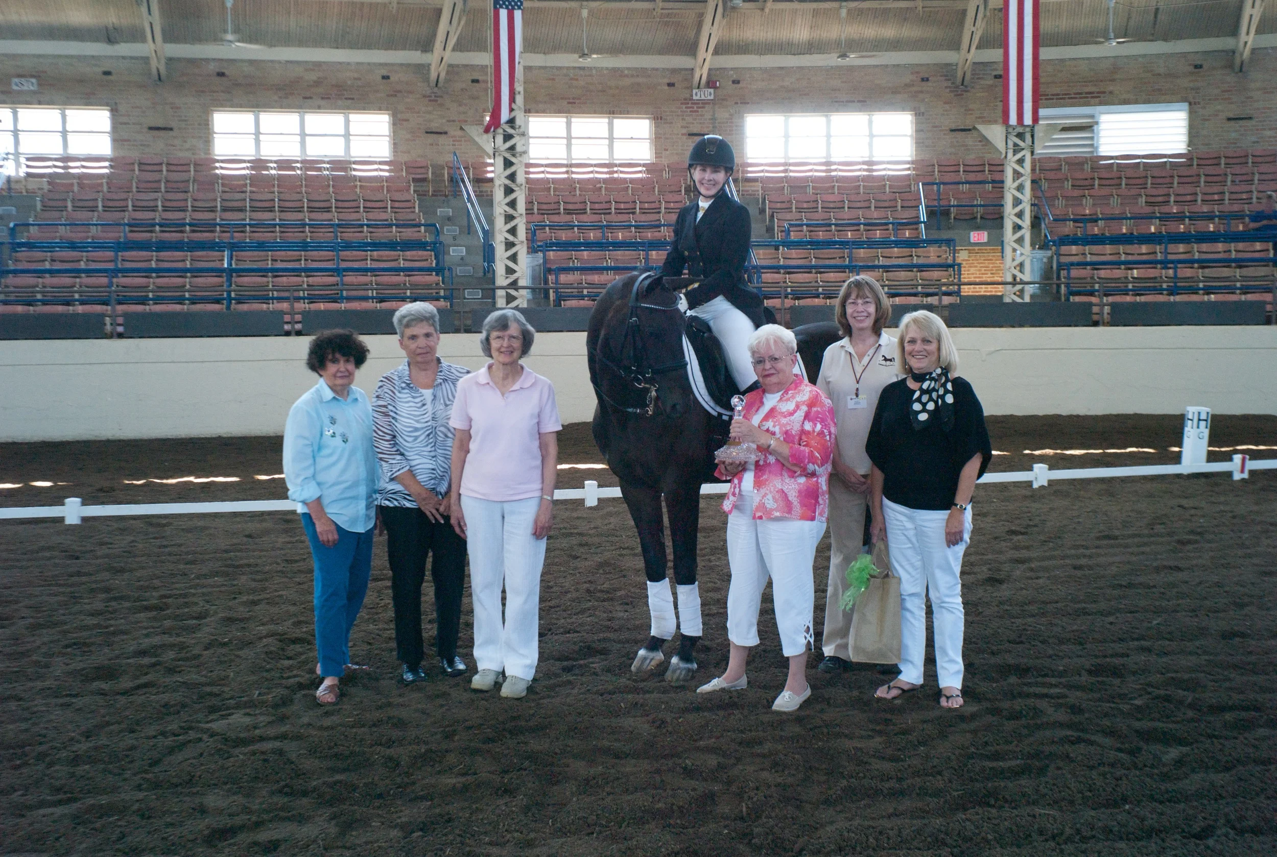 Rubin Raphael inspecting the Julia Trone Memorial Award presented by Carol Trone with friends of Julia and CLD President Nancy Simpson. Judy Ethel riding. (photo by Steve Todd, Studio 131)