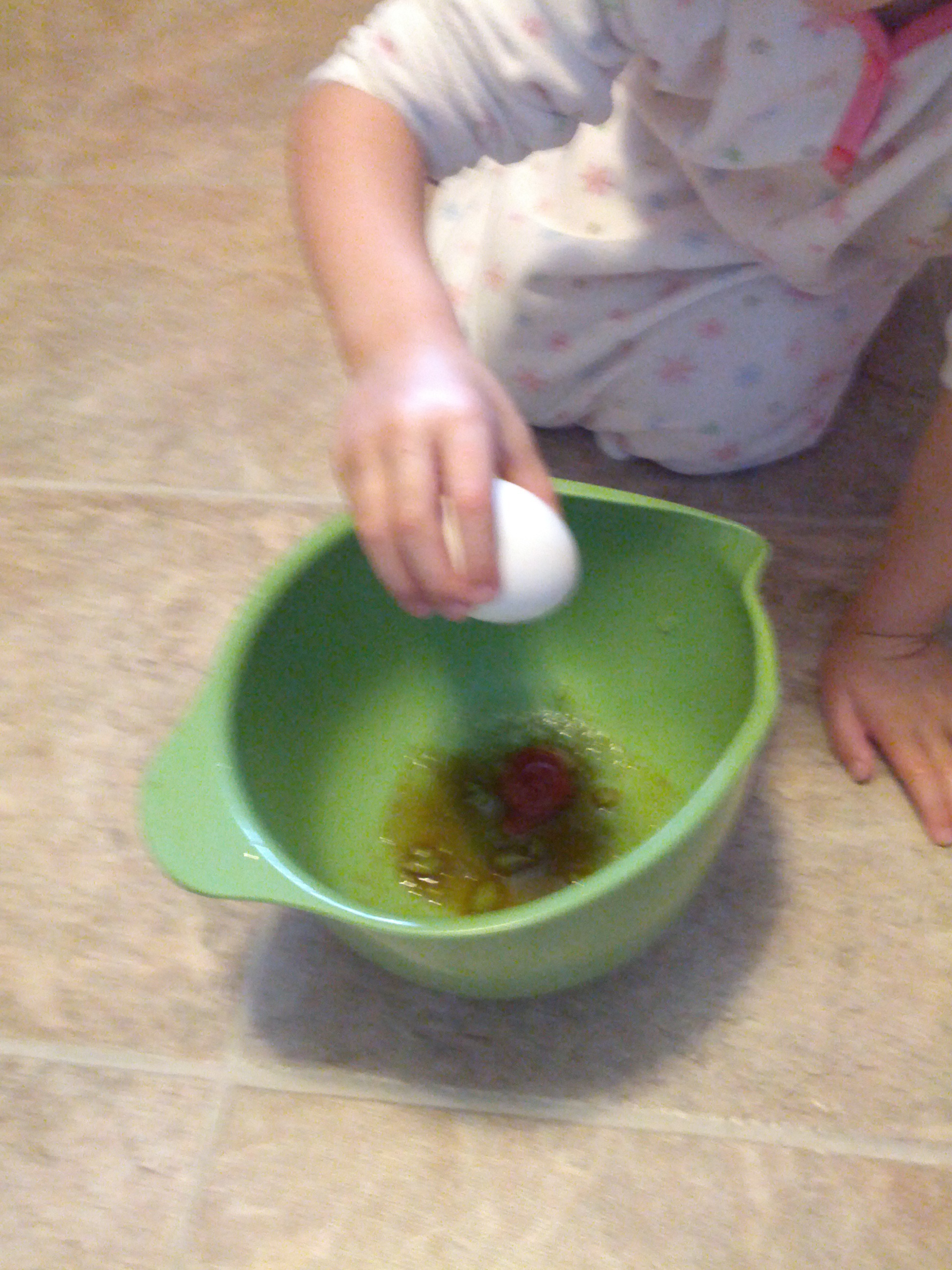 Adding an egg to the other wet ingredients.