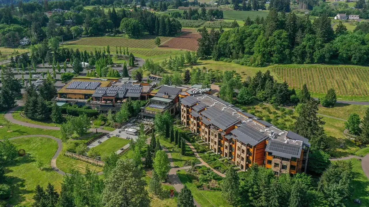 Aerial view of a modern residential complex surrounded by lush greenery and farmland.