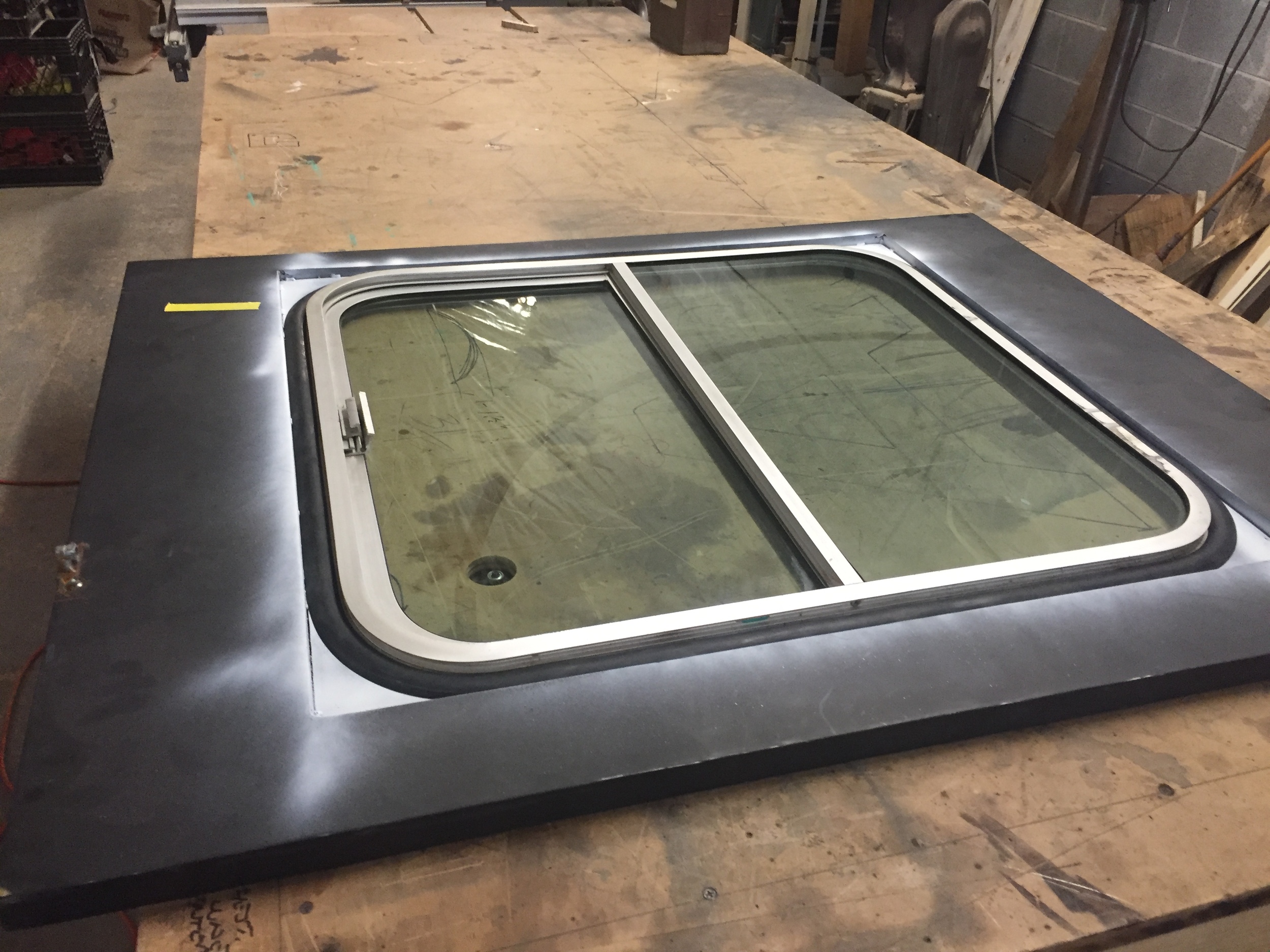 More work than it looks - steel frame and steel sheet, all welded and ground down to a smooth seam on inner and outer edges. The reclaimed aluminum-framed sliding window was fit in with new gasket after a lot of re-grinding. 