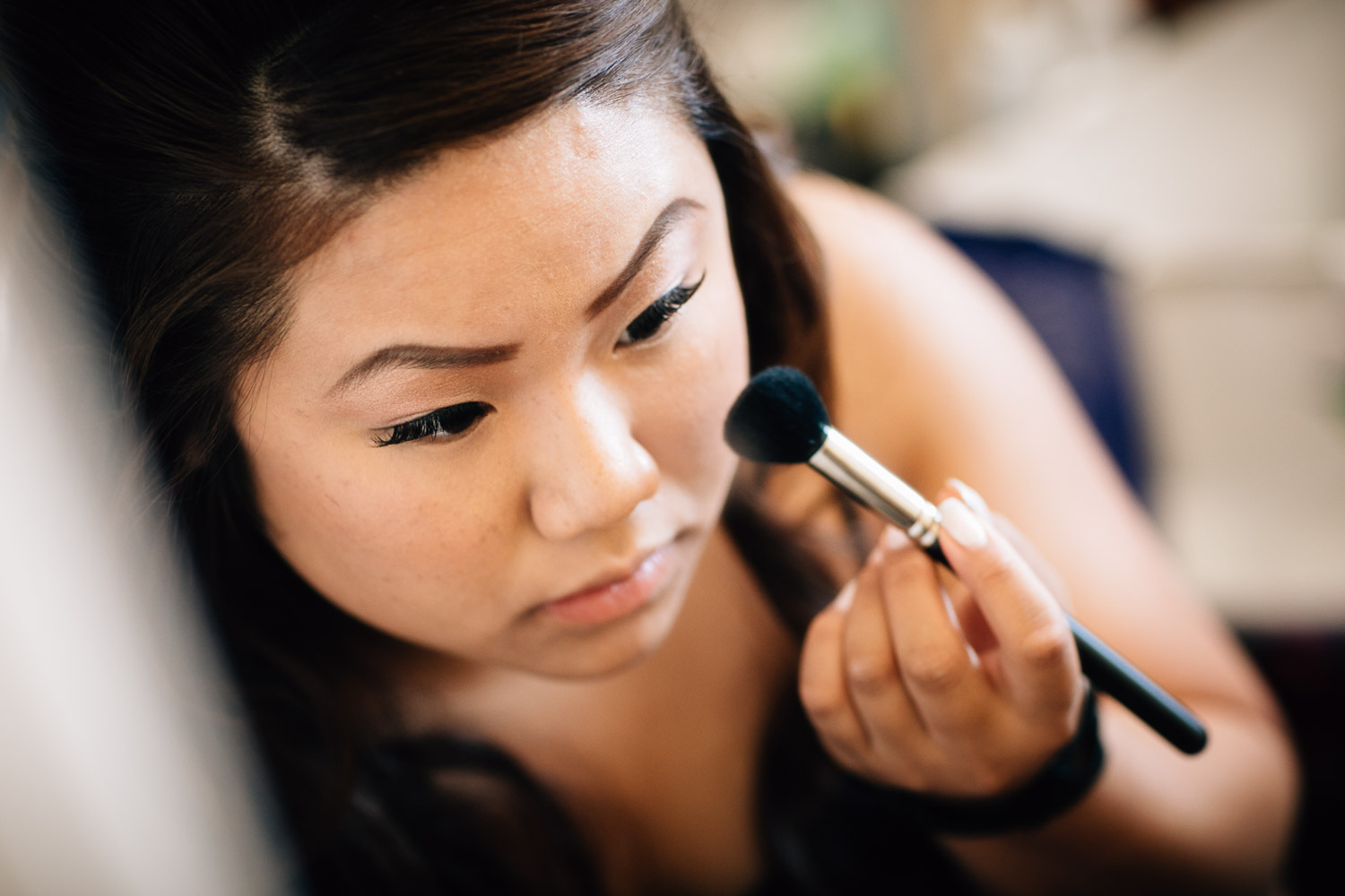 asian bride putting on makeup for wedding in surrey photography
