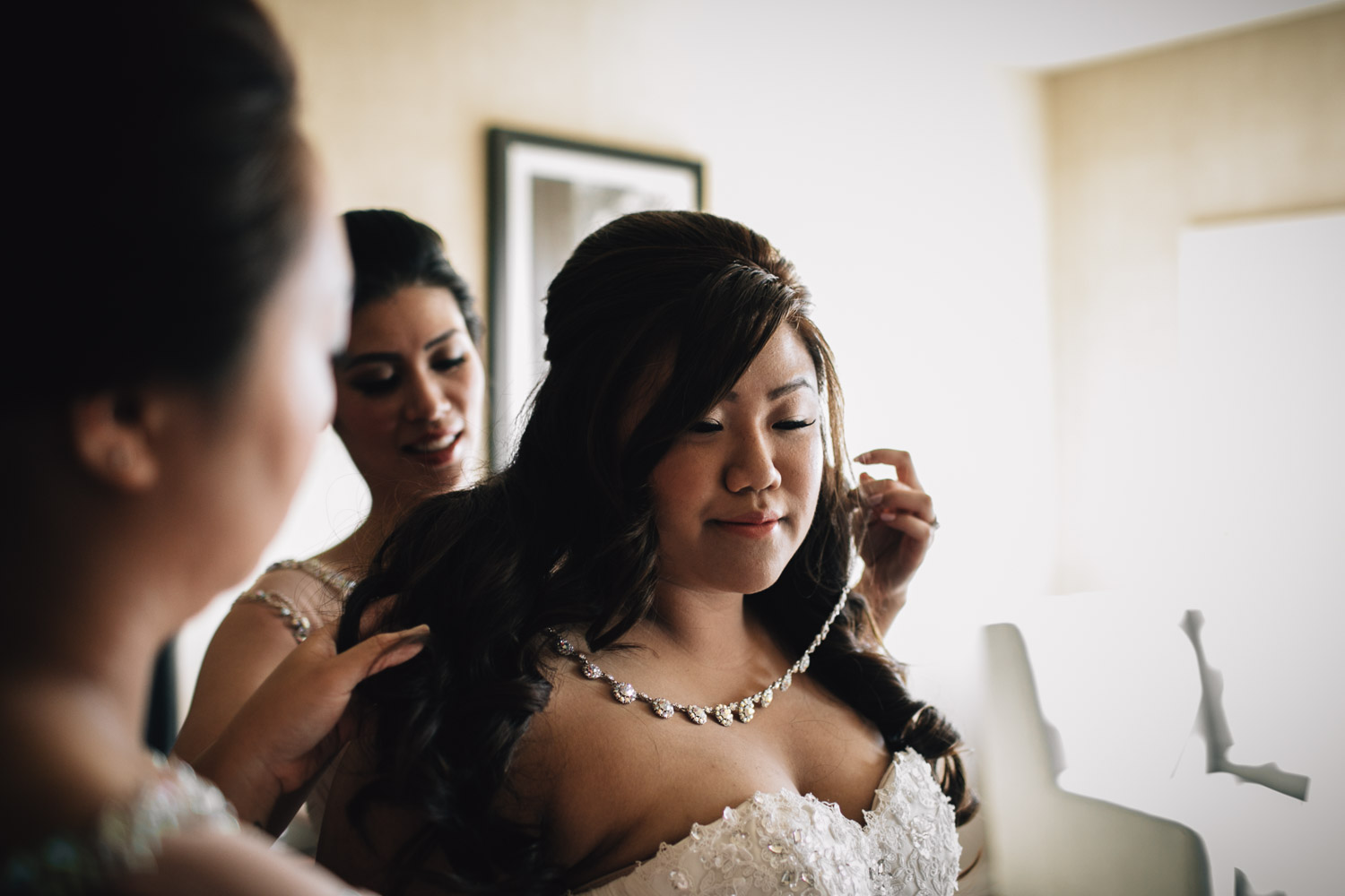 bride putting on jewllery for wedding in surrey photography