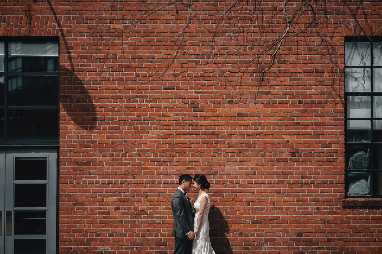 wedding portraits of bride and groom against brick wall in yaletown roundhouse vancouver bc
