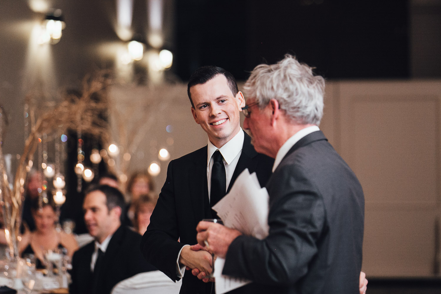 groom and father in law shake hands wedding reception at swaneset pitt meadows