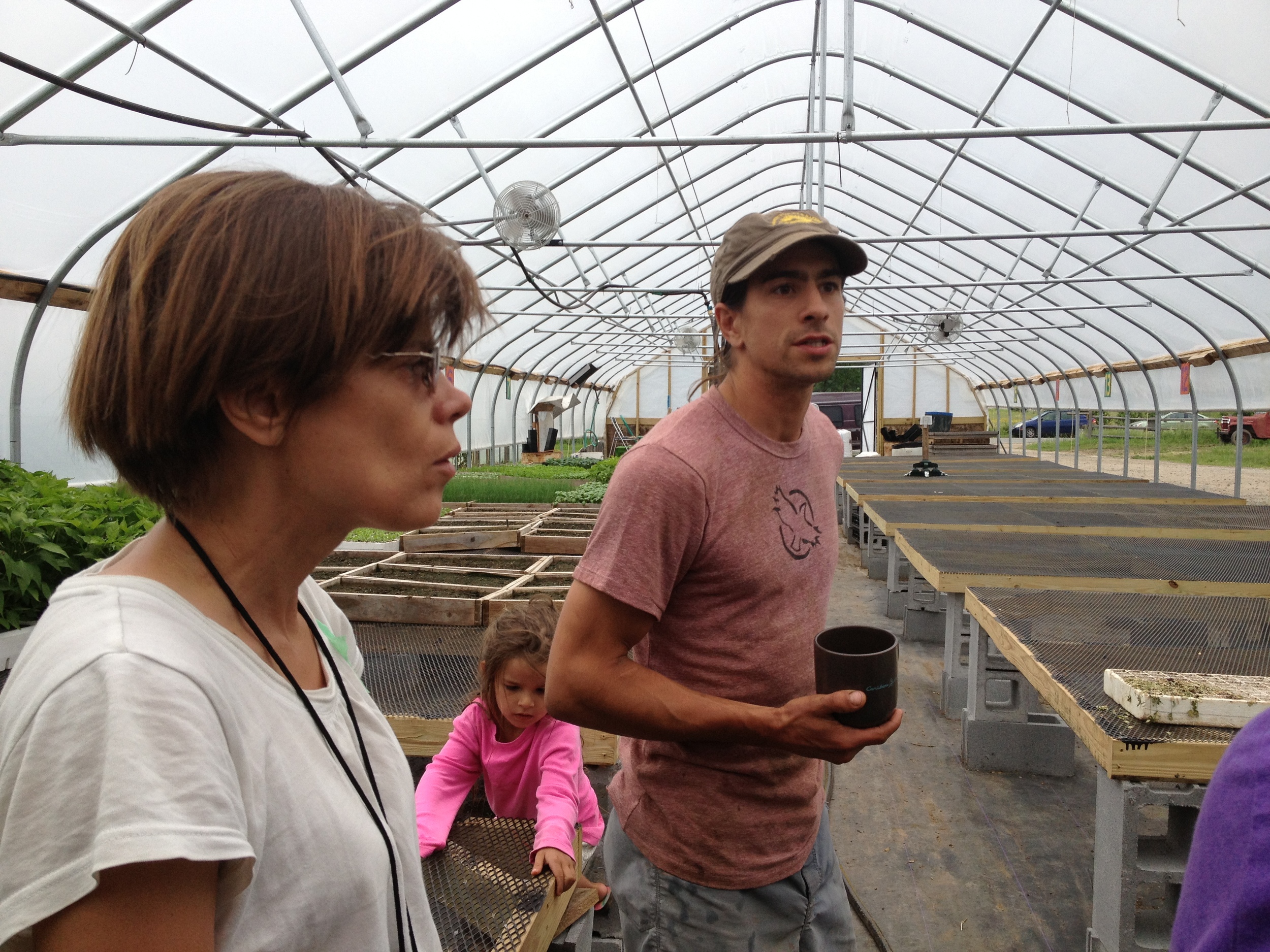  We started our tour de farms at  Fledging Crow Farm,  a CSA and market veggie operation just outside Keeseville. One of the farmers, Ian, stands in the center, showing us his propagation greenhouse. 