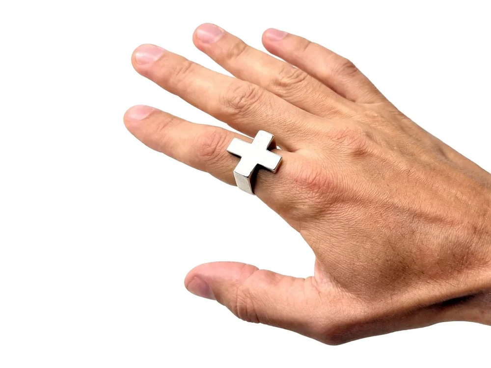 Sterling silver Plus Ring worn on a hand reaching in from the right