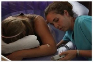Midwife in training, Celesta Bargatze assesses fetal heart tones while the mother labors in a birth pool.